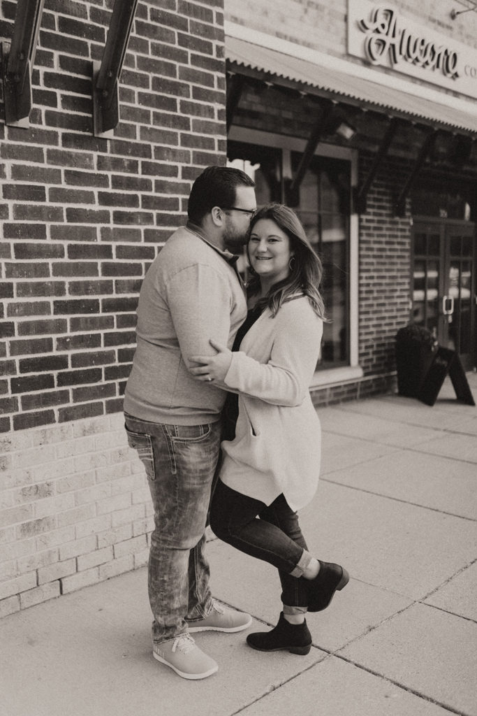 Outdoor engagement photos with brick building and winter outfits