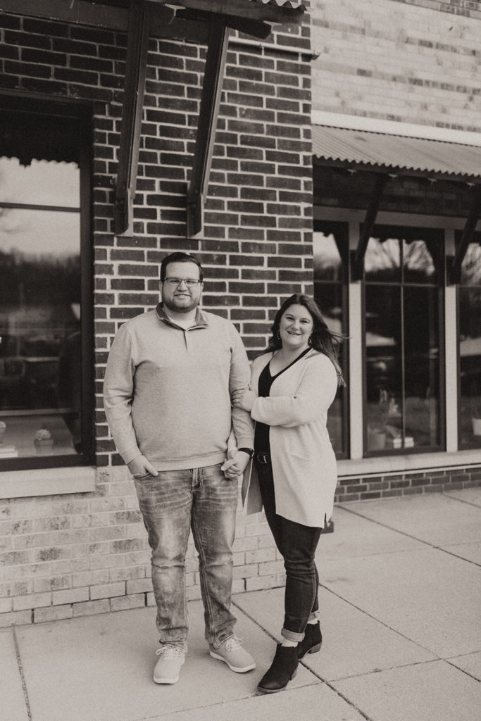 Outdoor engagement photos with brick building and winter outfits