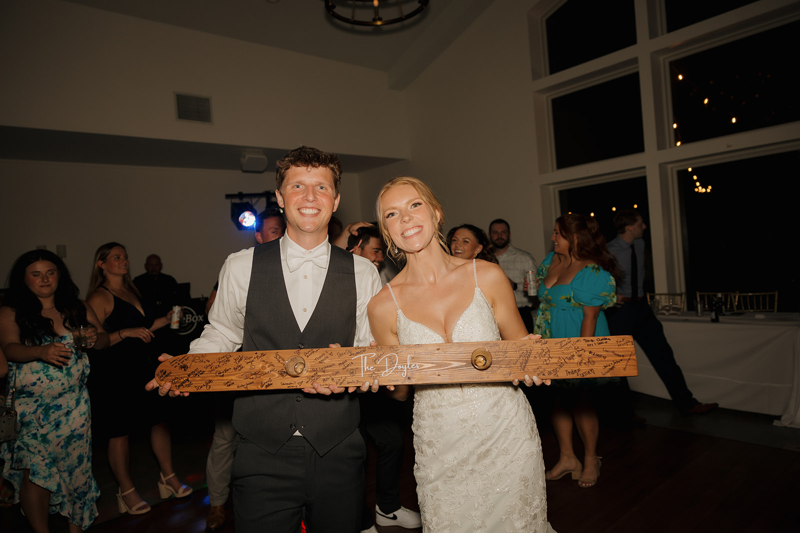 Bride and Groom smile with their shotski guest book on the dance floor at their wedding at The Eloise in Mount Horeb