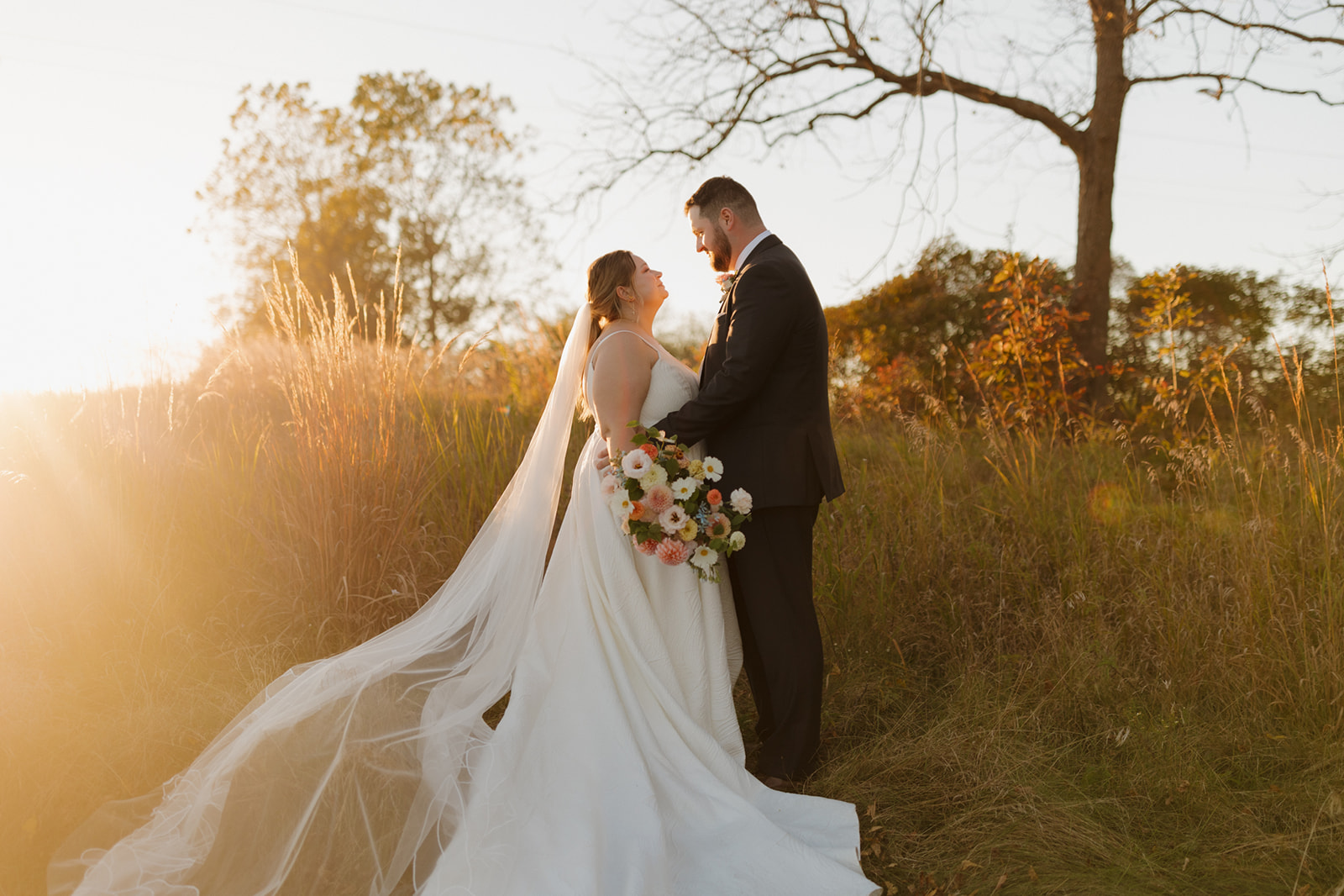 Bride and groom sharing a sunset moment in a golden field near Madison, Wisconsin