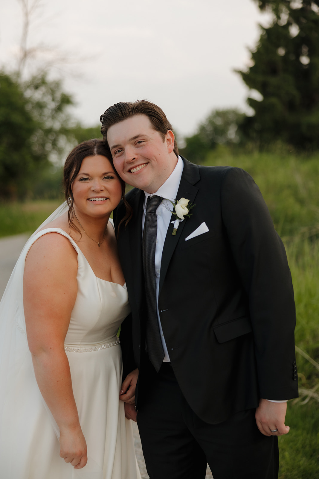 Smiling newlyweds posing together outdoors after their Madison wedding celebration