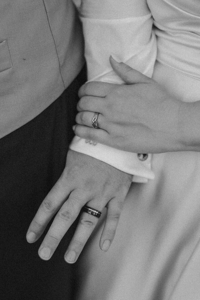 Detail of wedding rings as the couple holds hands during their outdoor wedding in Wisconsin.

