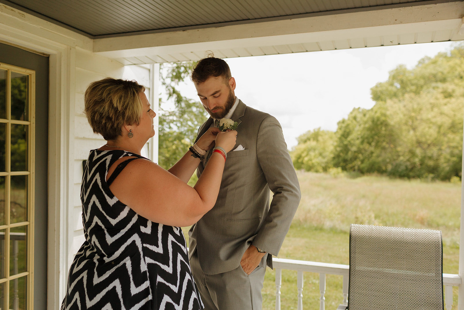 Groom's mother helping him get ready for wedding day