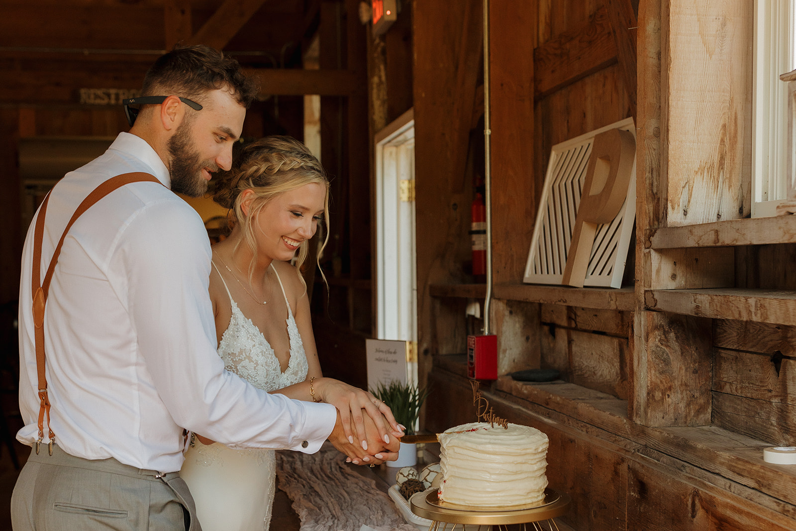 Couple cutting wedding cake as newly married husband and wife during Wisconsin wedding ceremony after planning outdoor wedding ideas