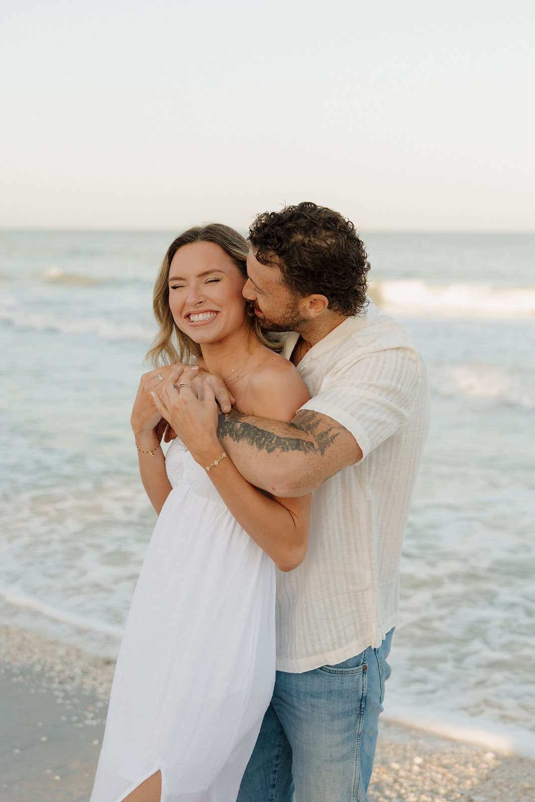 Playful beach hug with the couple grinning ear to ear during their florida elopement by the ocean