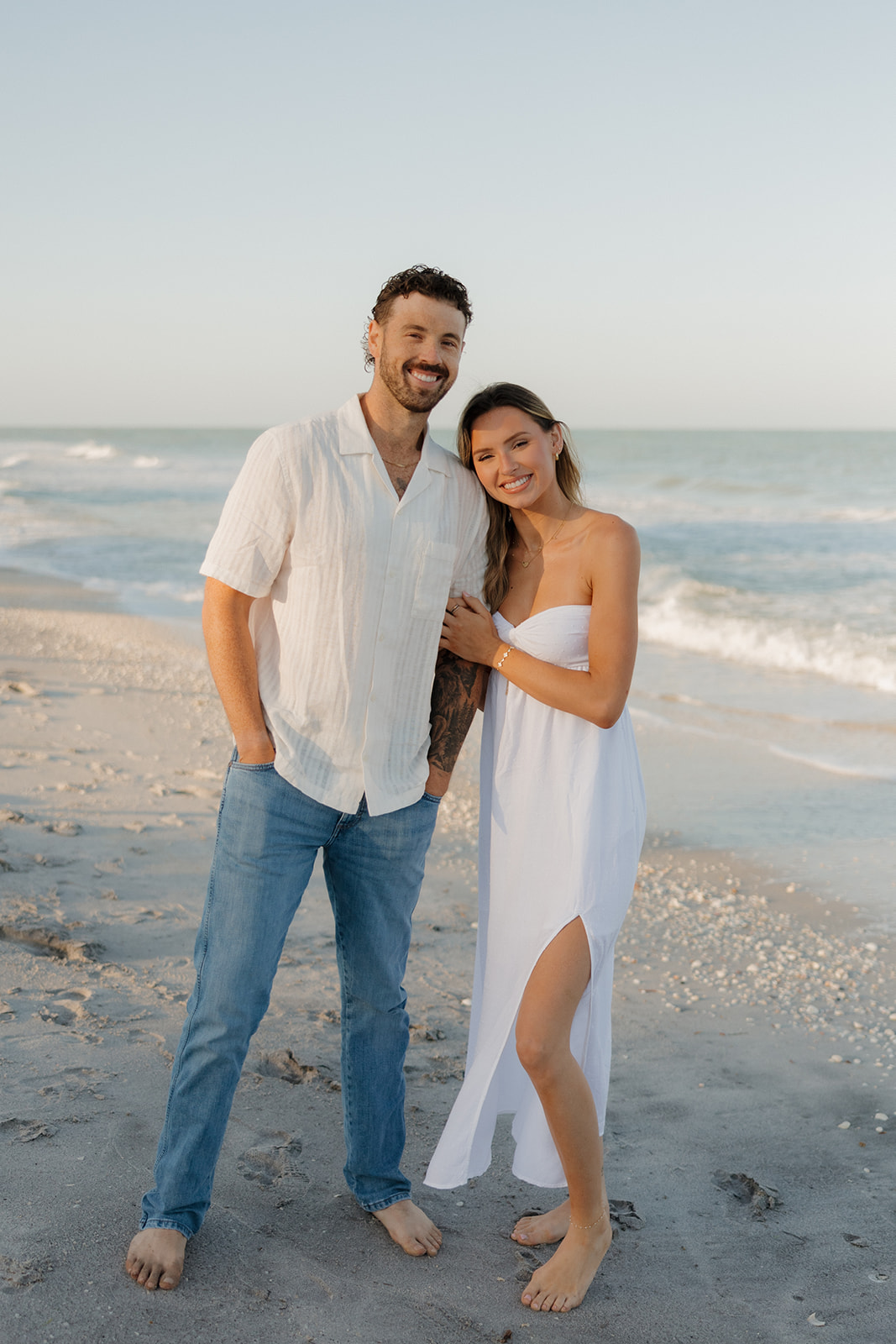 Barefoot couple posing together on the shoreline during golden hour for their florida elopement