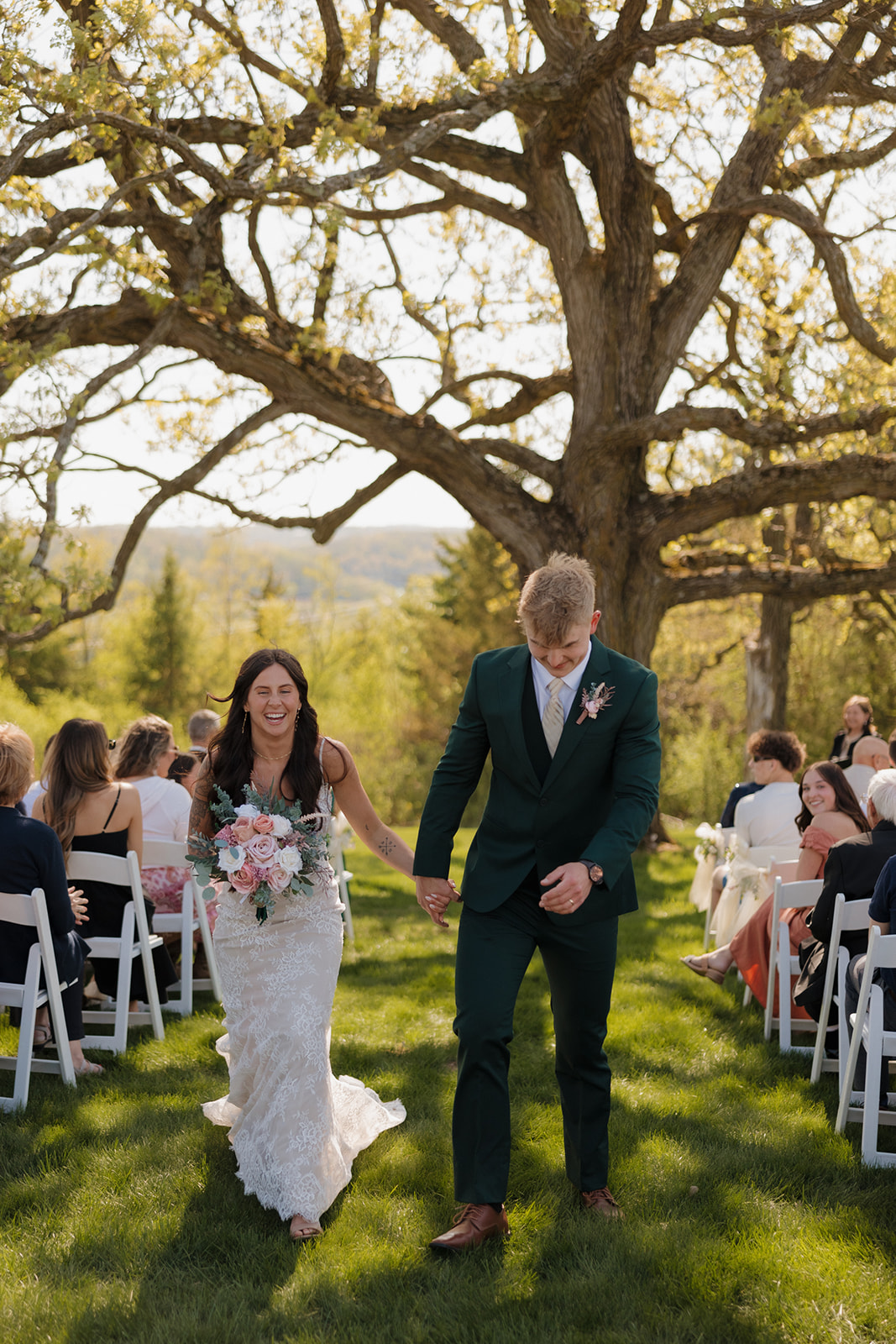 Bride and groom walk up the aisle with huge smiles and bouquet in hand, newly married and beaming with post-ceremony joy – this image radiates intimate wedding energy.