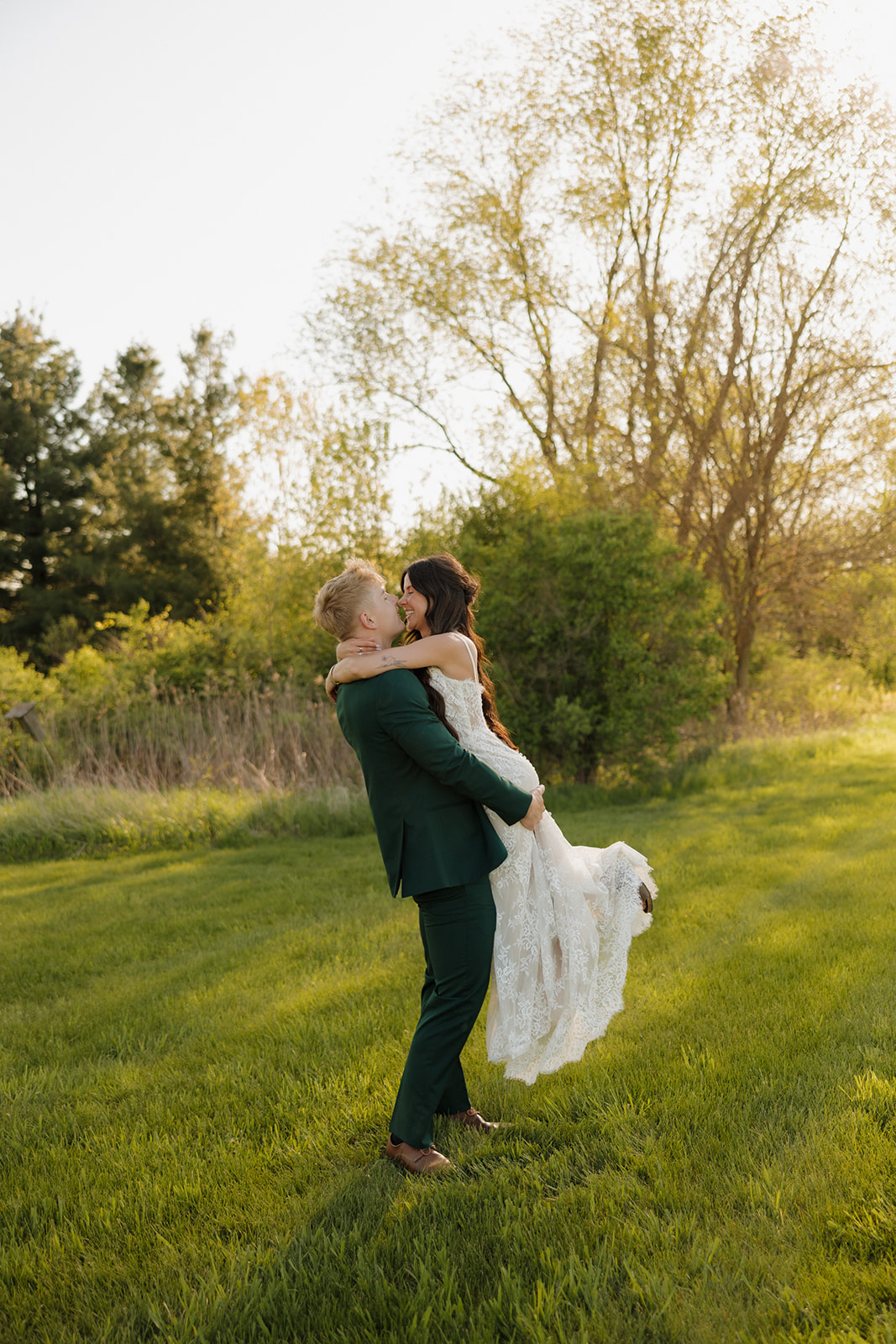 Groom lifts the bride into a joyful spin during golden hour portraits in Madison, Wisconsin – a perfect example of intimate wedding ideas with romantic, carefree energy.
