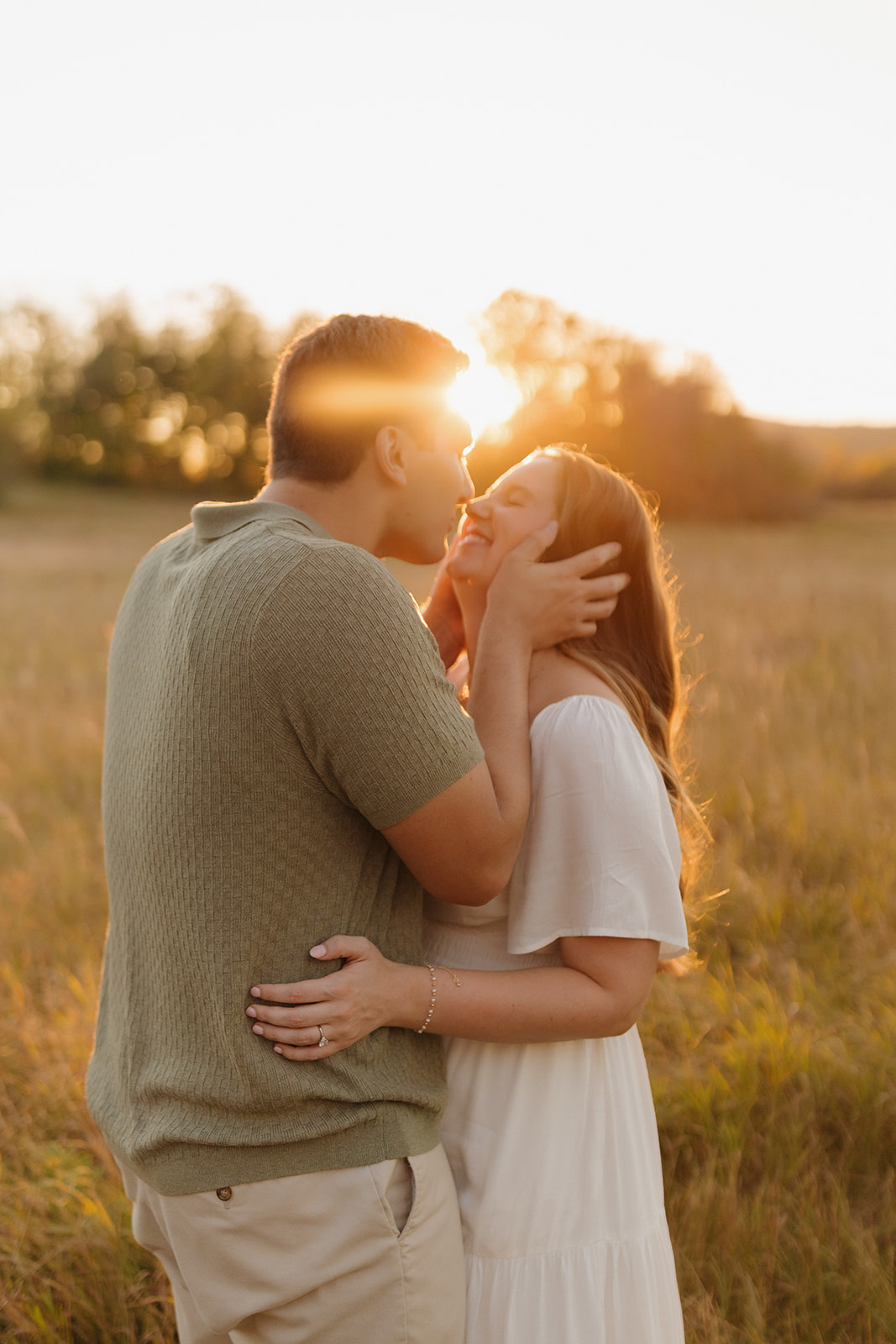 Romantic outdoor engagement photos with a couple kissing in a sun-drenched Wisconsin meadow.