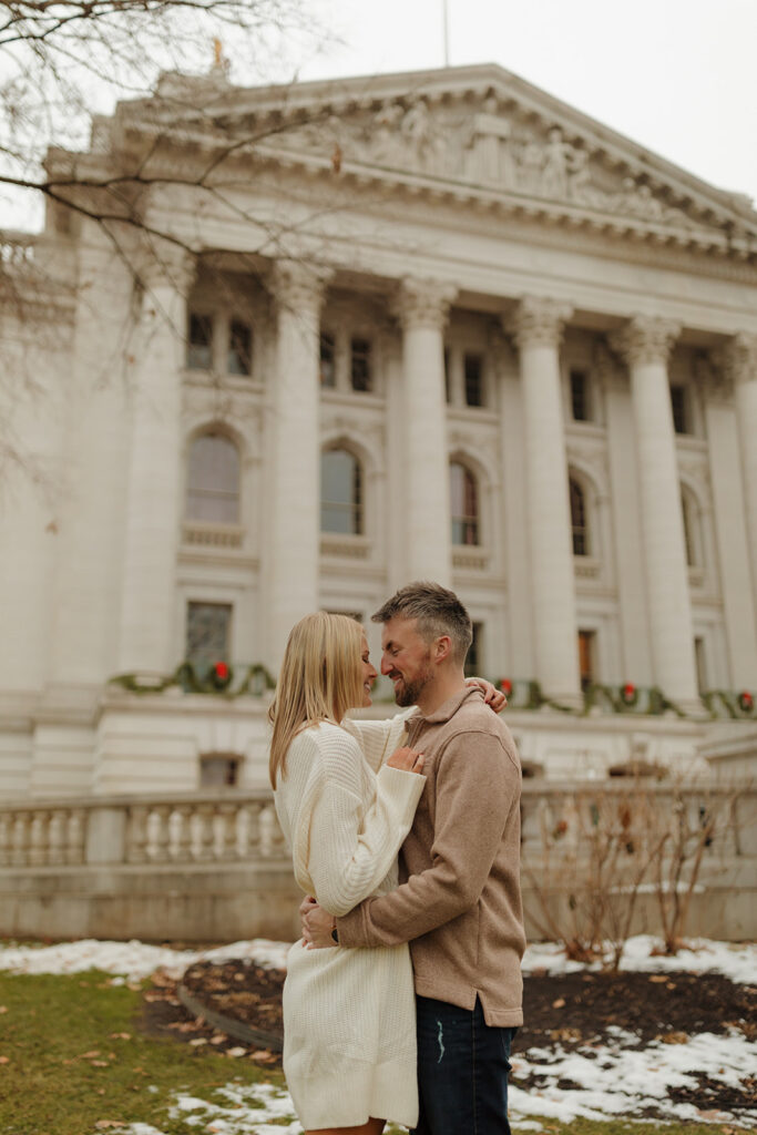 Winter engagement session with a cozy couple cuddled up outside the Wisconsin Capitol.

