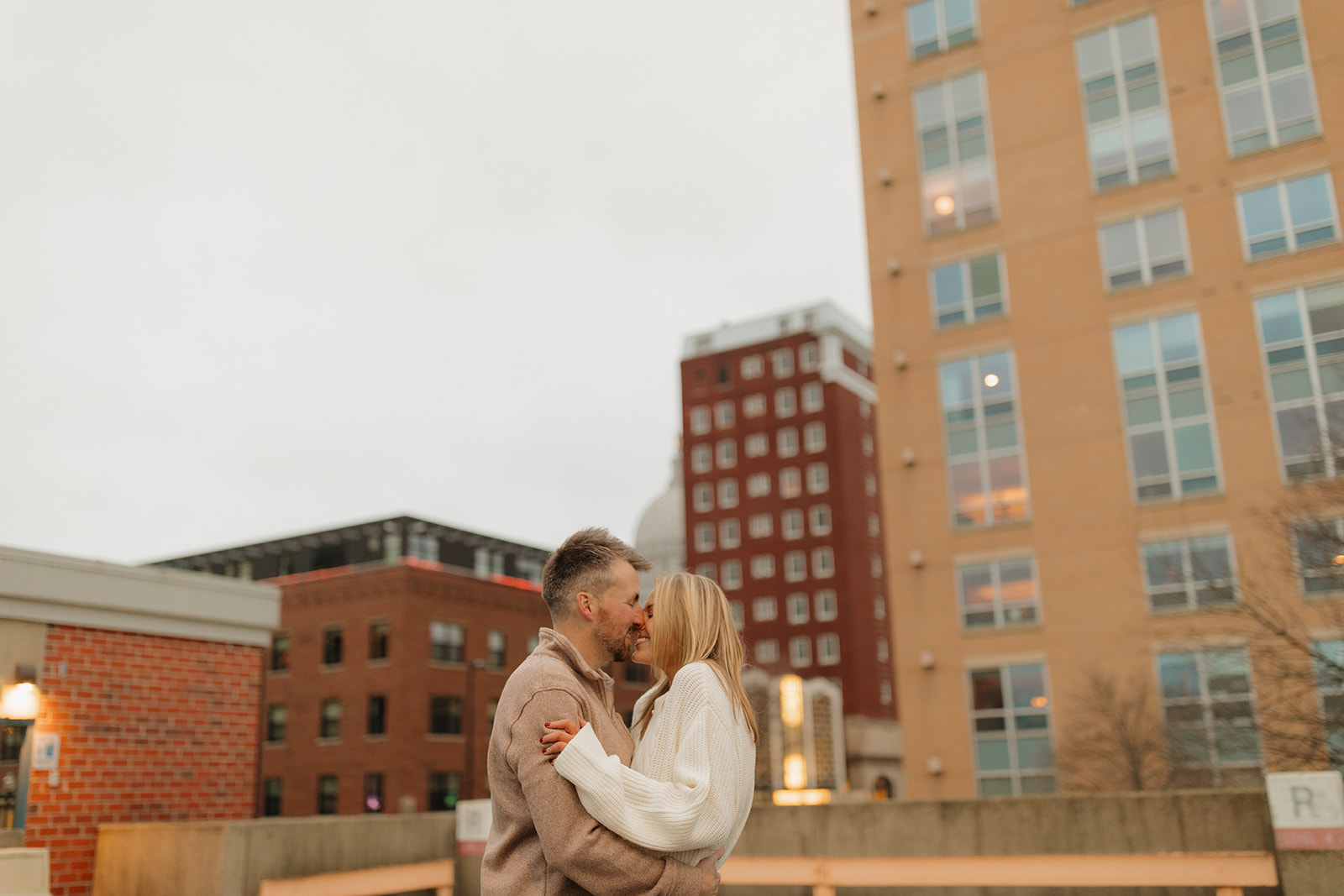 Urban outdoor engagement photos with a couple smiling against a downtown Madison skyline.

