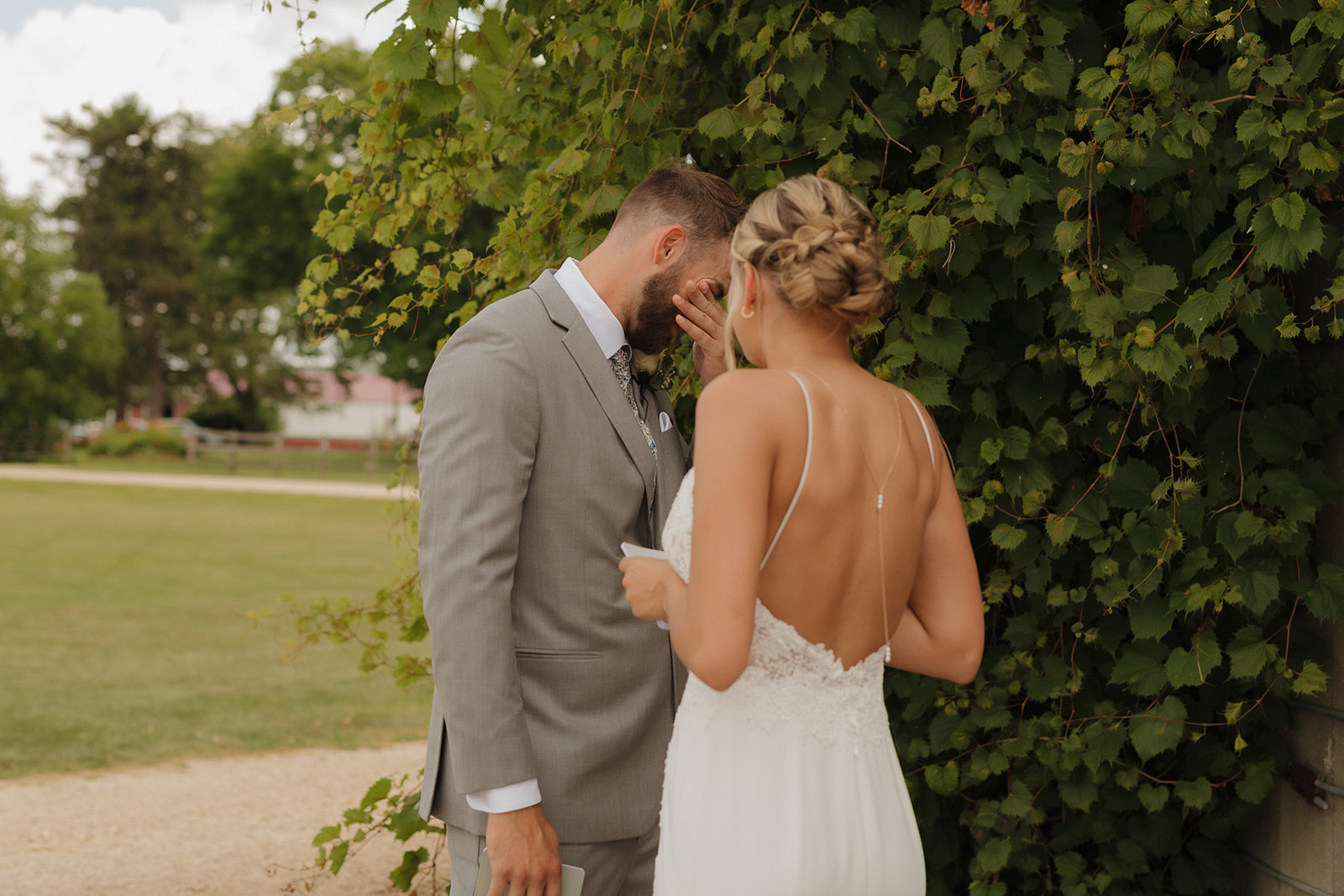 Groom wiping away tears while listening to his bride read her vows during private vow reading - outdoor wedding ideas for intentional and unique moments like this were perfect