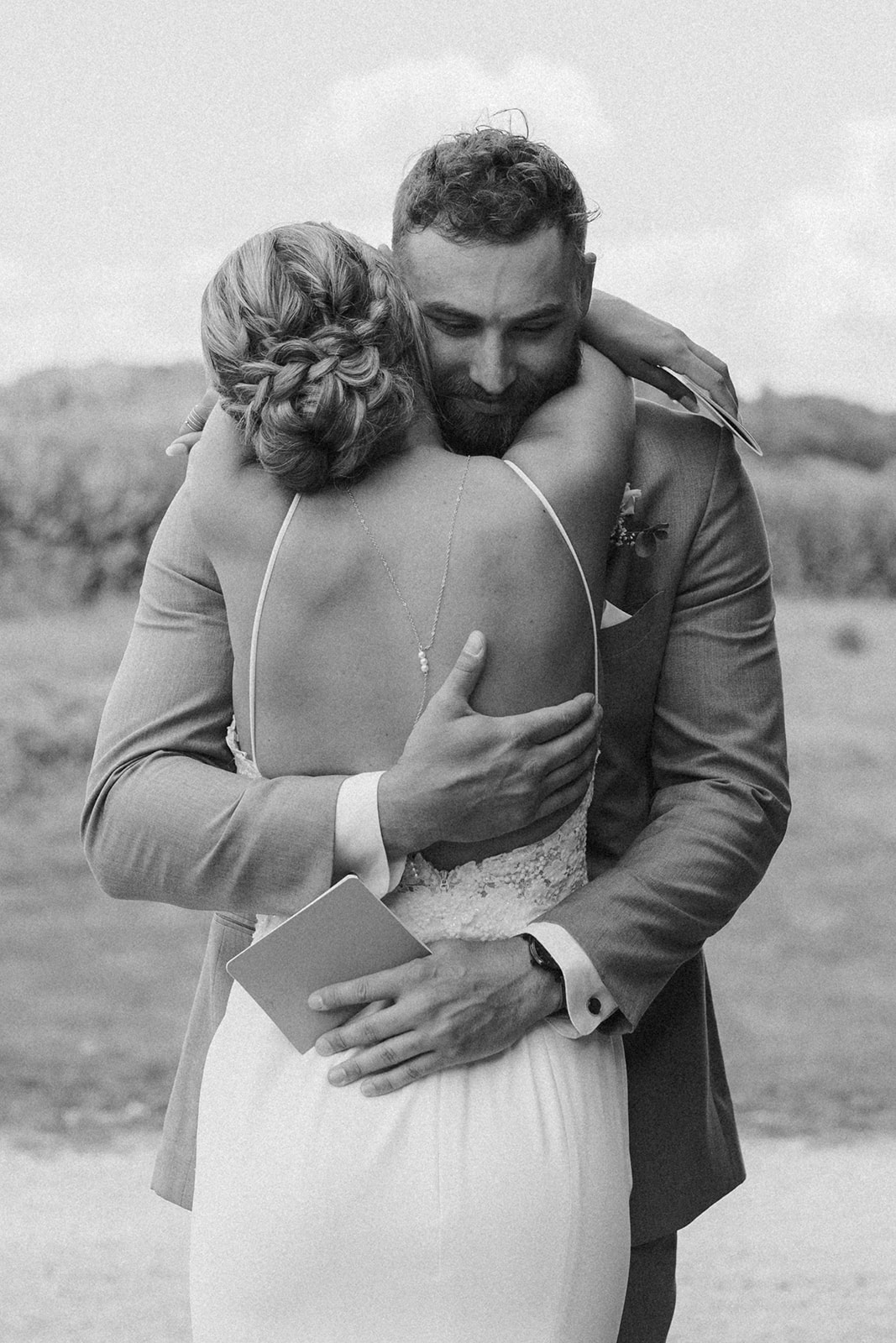 Close up of bride hugging her groom after listening to him read his vows to her