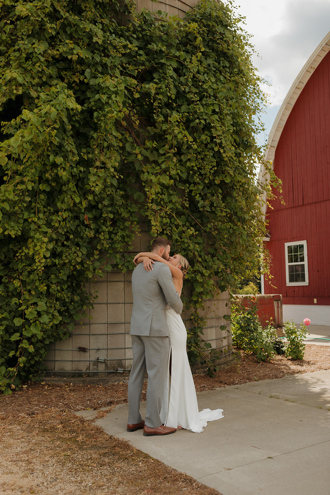 Bride and groom kiss during private vow reading and first look, while embracing on wedding day