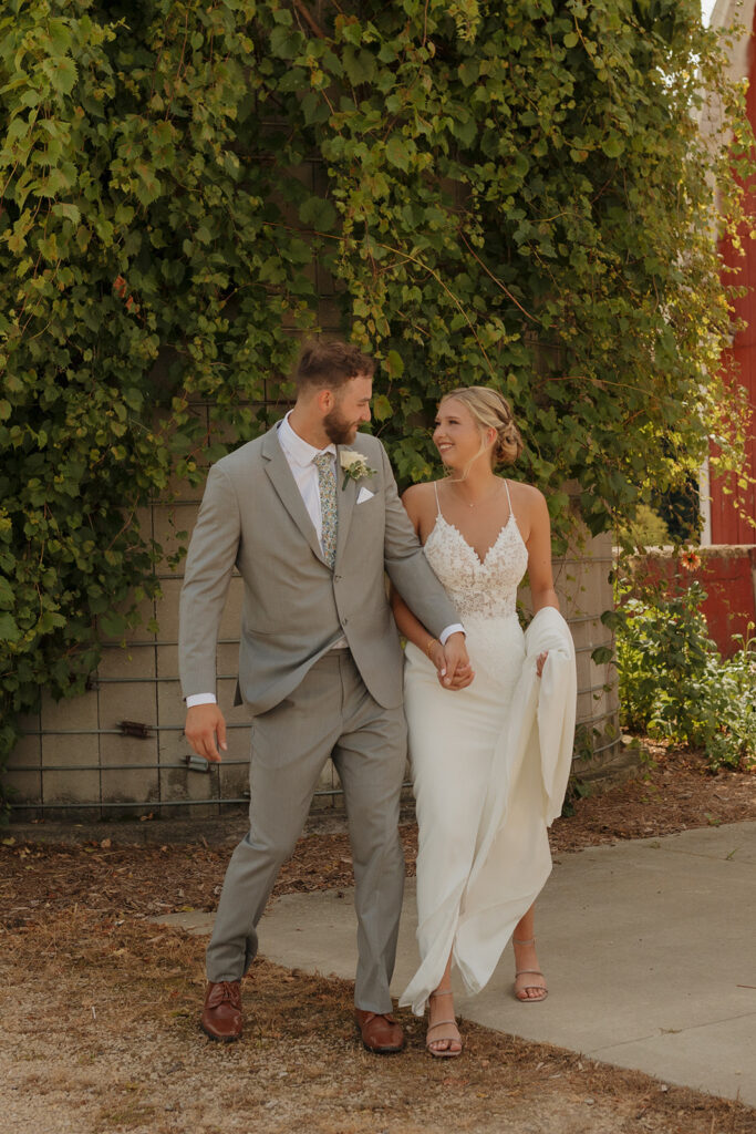 Wedding couple bumping hips while walking and being silly together during photos