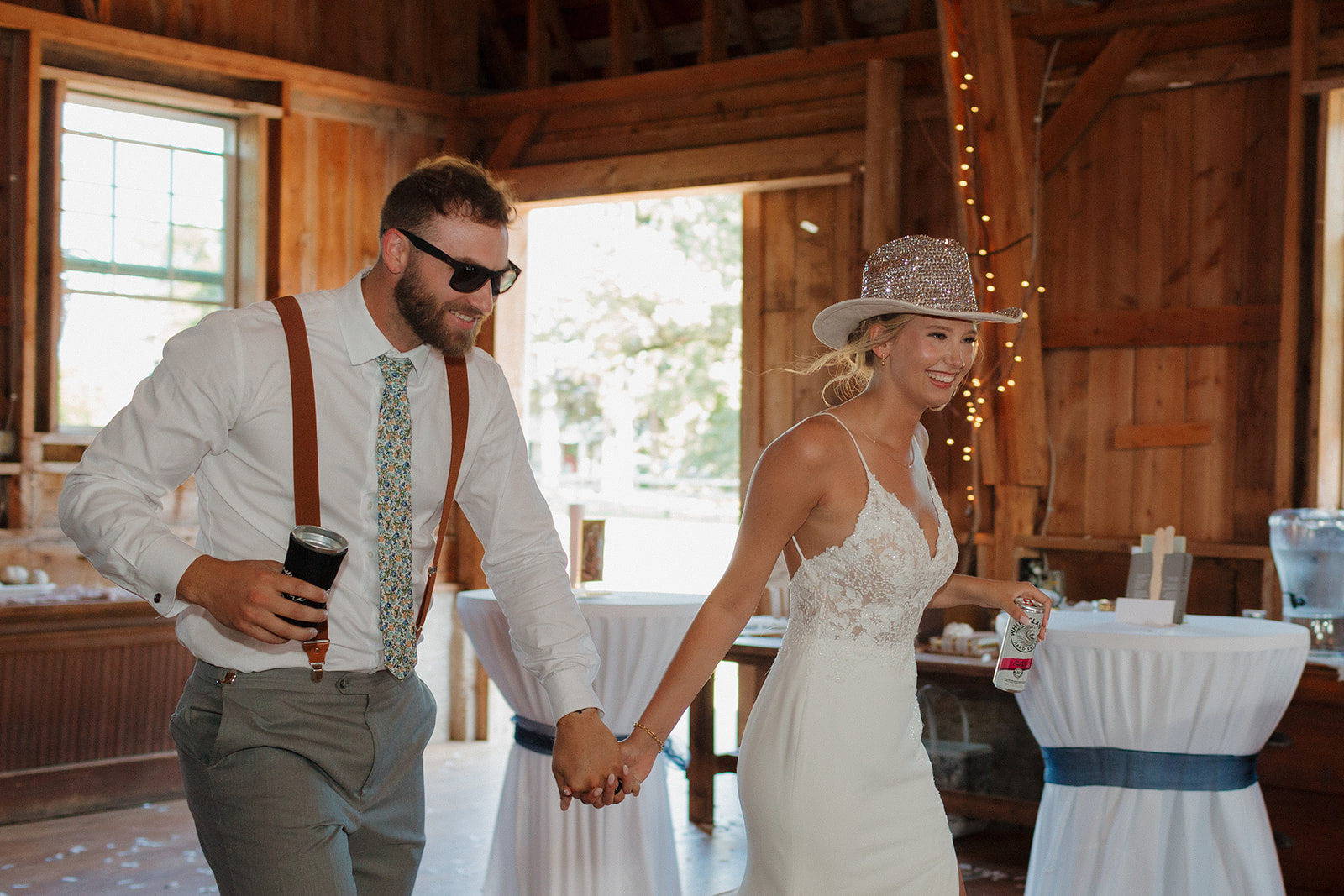 Wedding couple enters reception wearing sparkly cowboy hat and sunglasses getting ready to celebrate