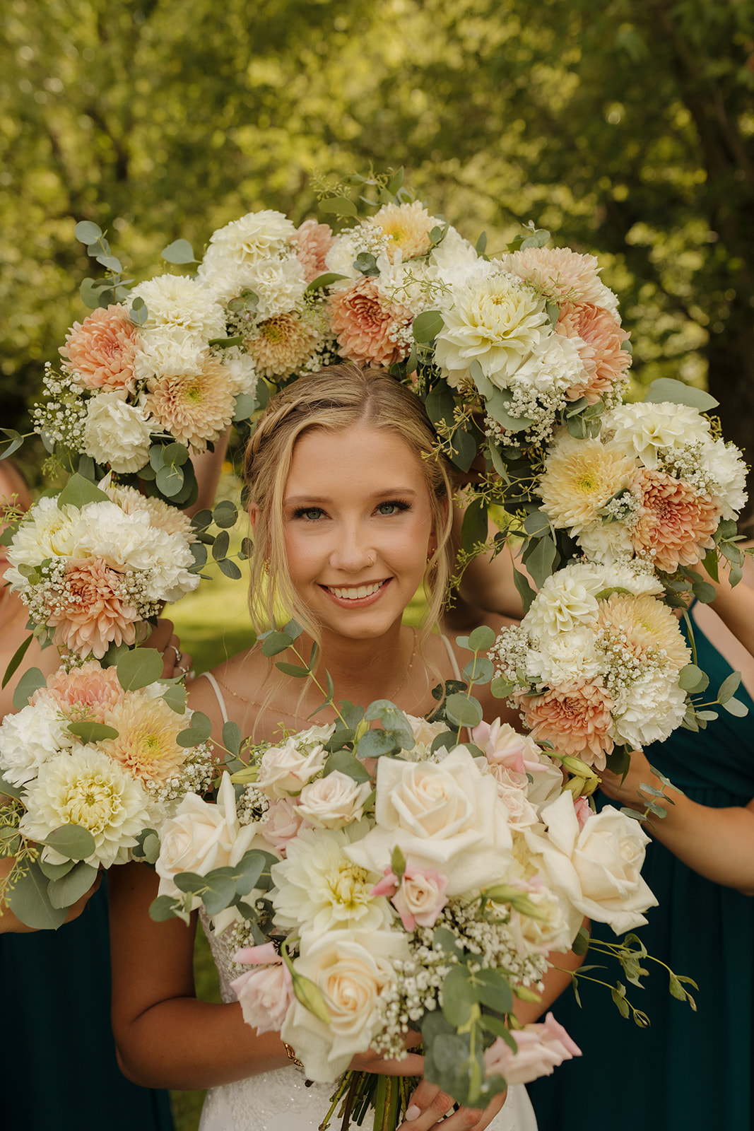Bride smiling with bouquets surrounding her - fun outdoor wedding ideas from her planning coming to life