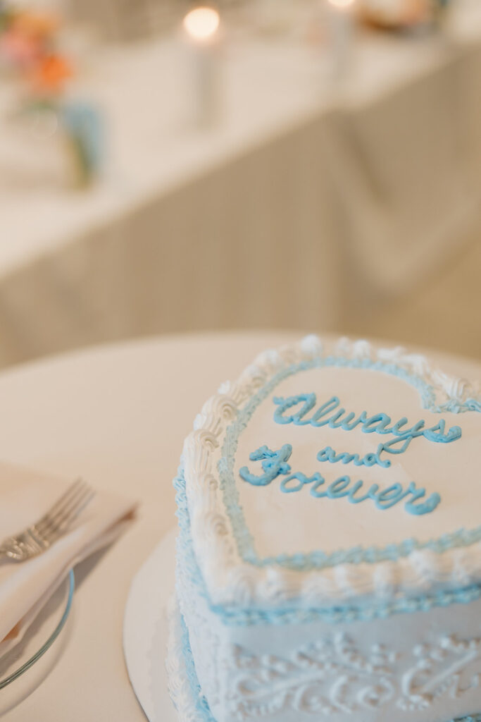 Vintage-inspired wedding cake with light blue piping and “Always and Forever” written in cursive.