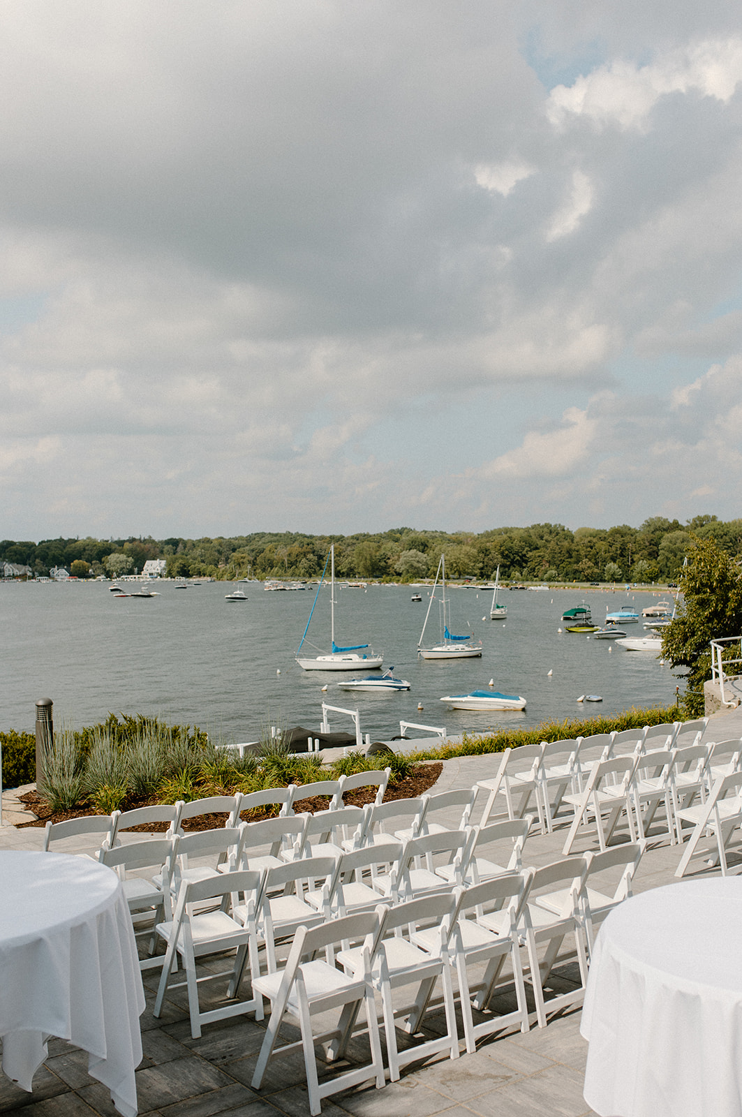 Ceremony chairs and sailboats set the scene for a romantic lakeside wedding in Lake Geneva