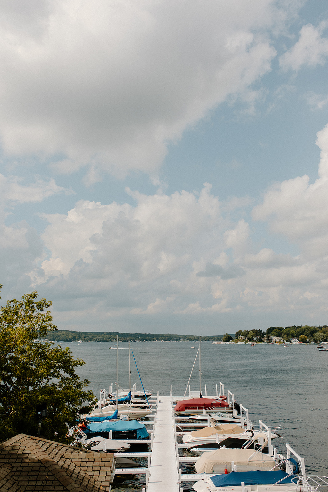 View of a private dock with colorful boats and blue skies over Lake Geneva