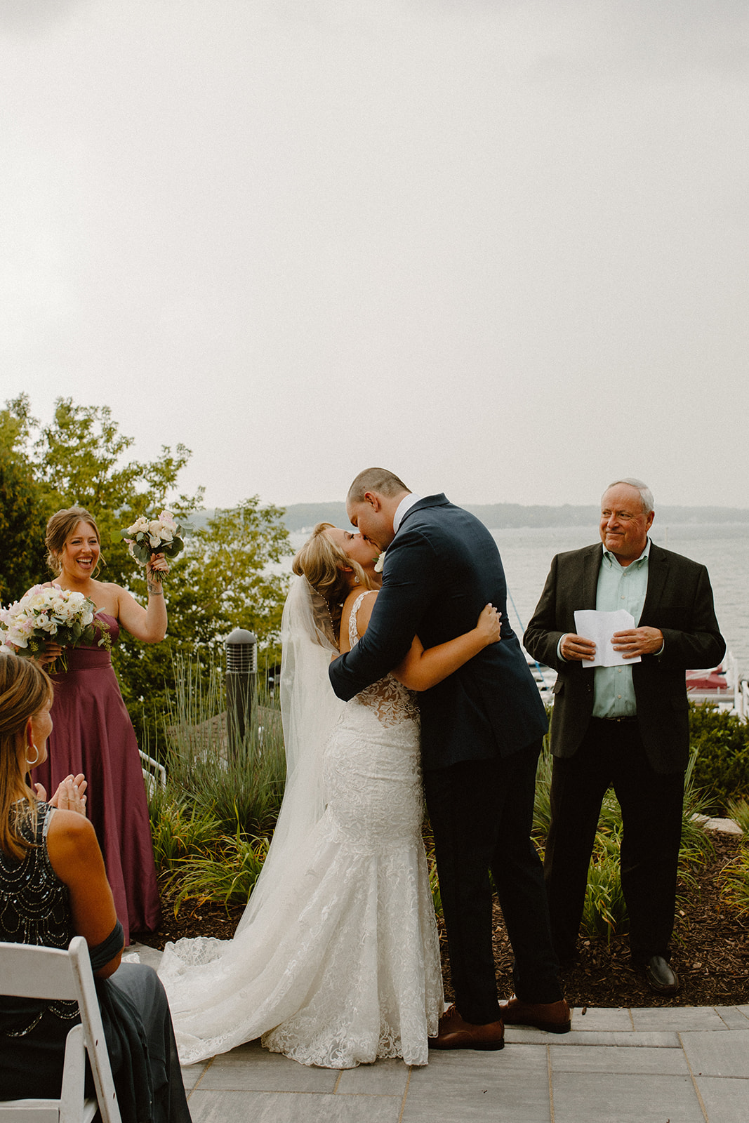 Bride and groom share their first kiss as newlyweds during an outdoor Lake Geneva wedding ceremony