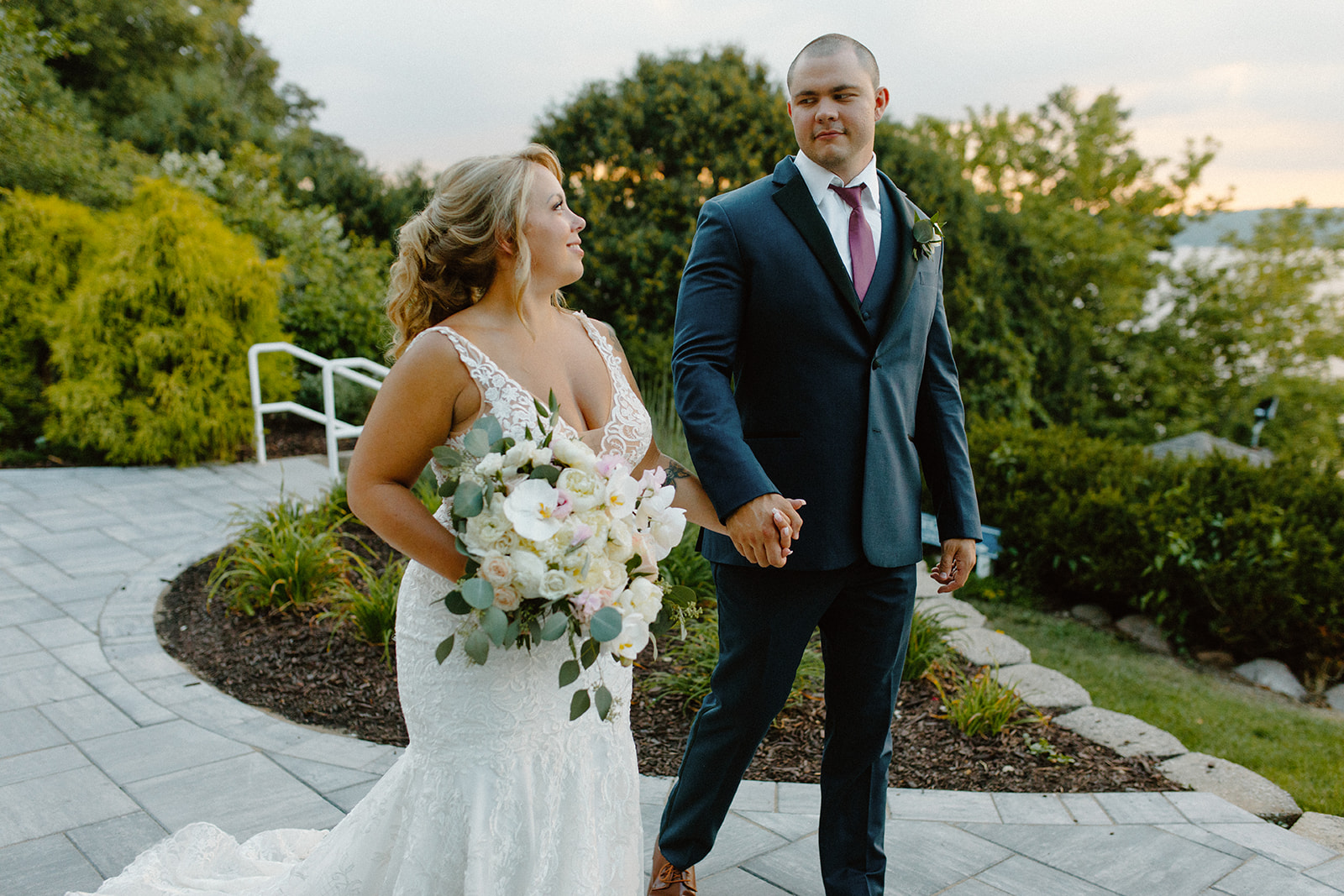 Bride holding her bouquet and smiling at her groom during a quiet moment together