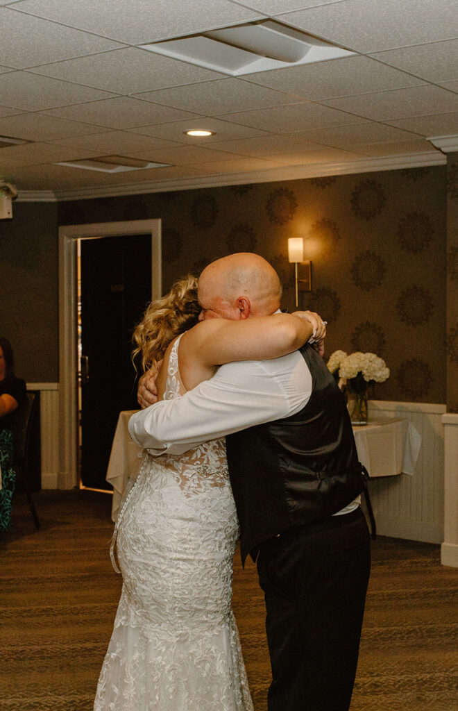 Bride hugging her father tightly during their heartfelt father-daughter dance

