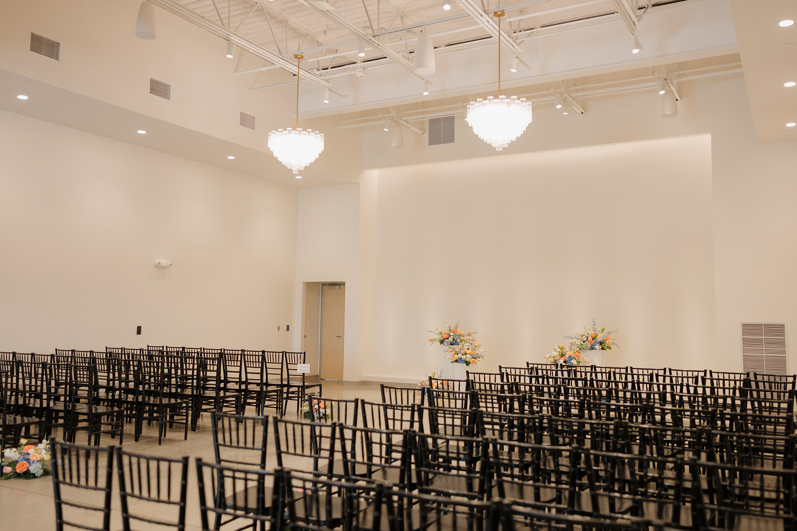 Bright and airy ceremony space with rows of black chairs and whimsical floral arrangements—classic Madison Wisconsin wedding vibes