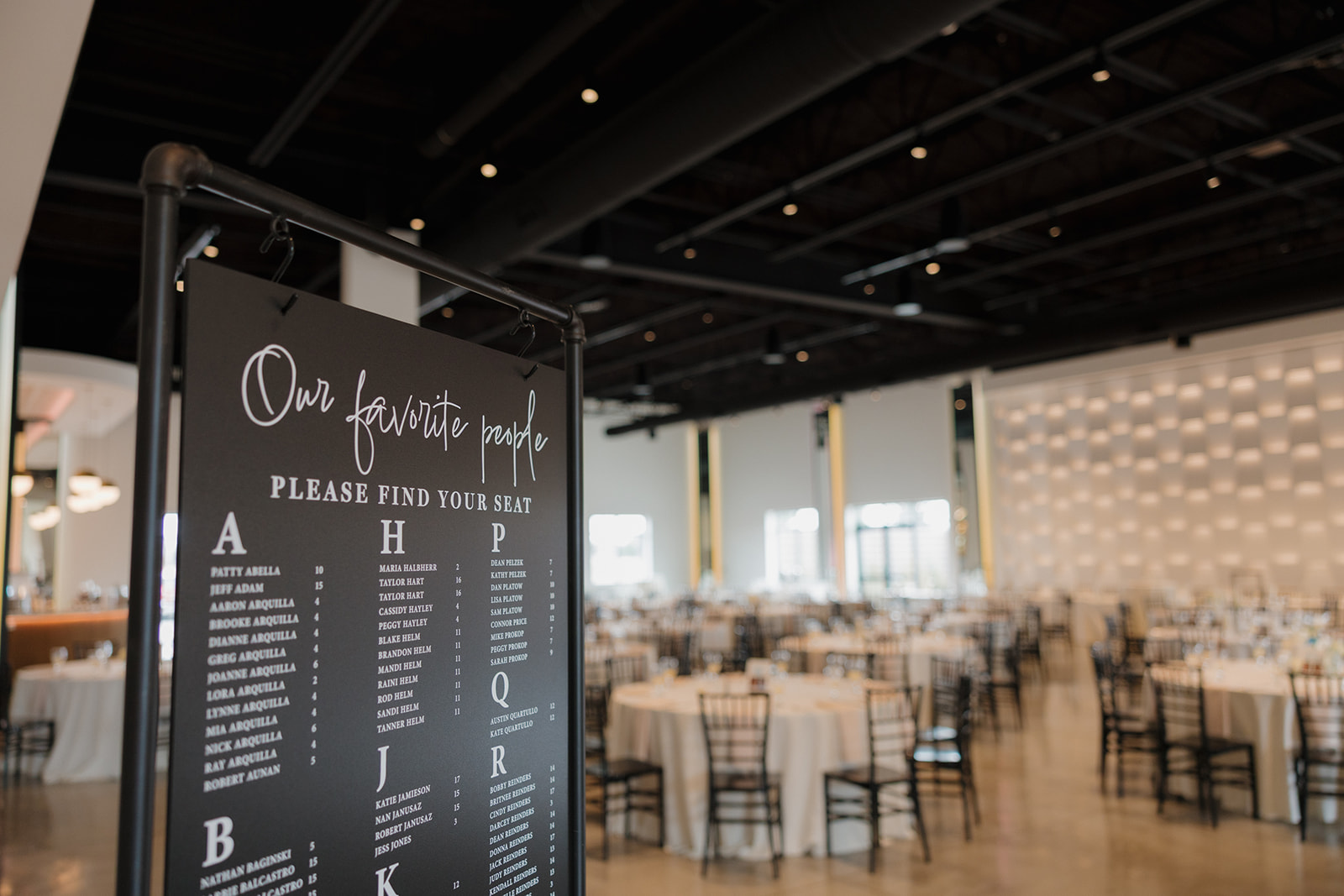 Chic black-and-white seating chart welcomes guests to a stylish modern wedding reception.

