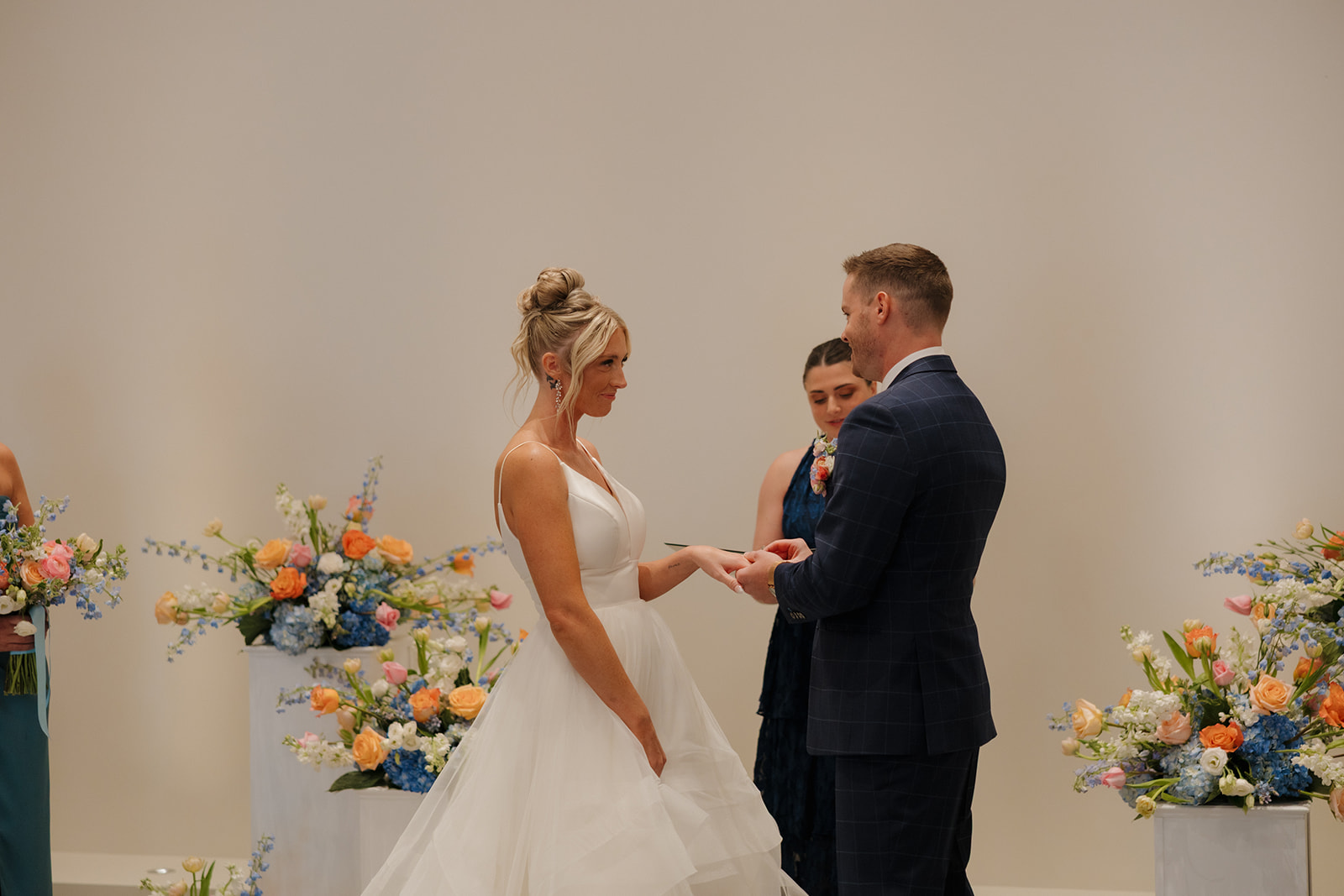 Intimate vow exchange surrounded by colorful spring florals during a Madison Wisconsin wedding ceremony.
