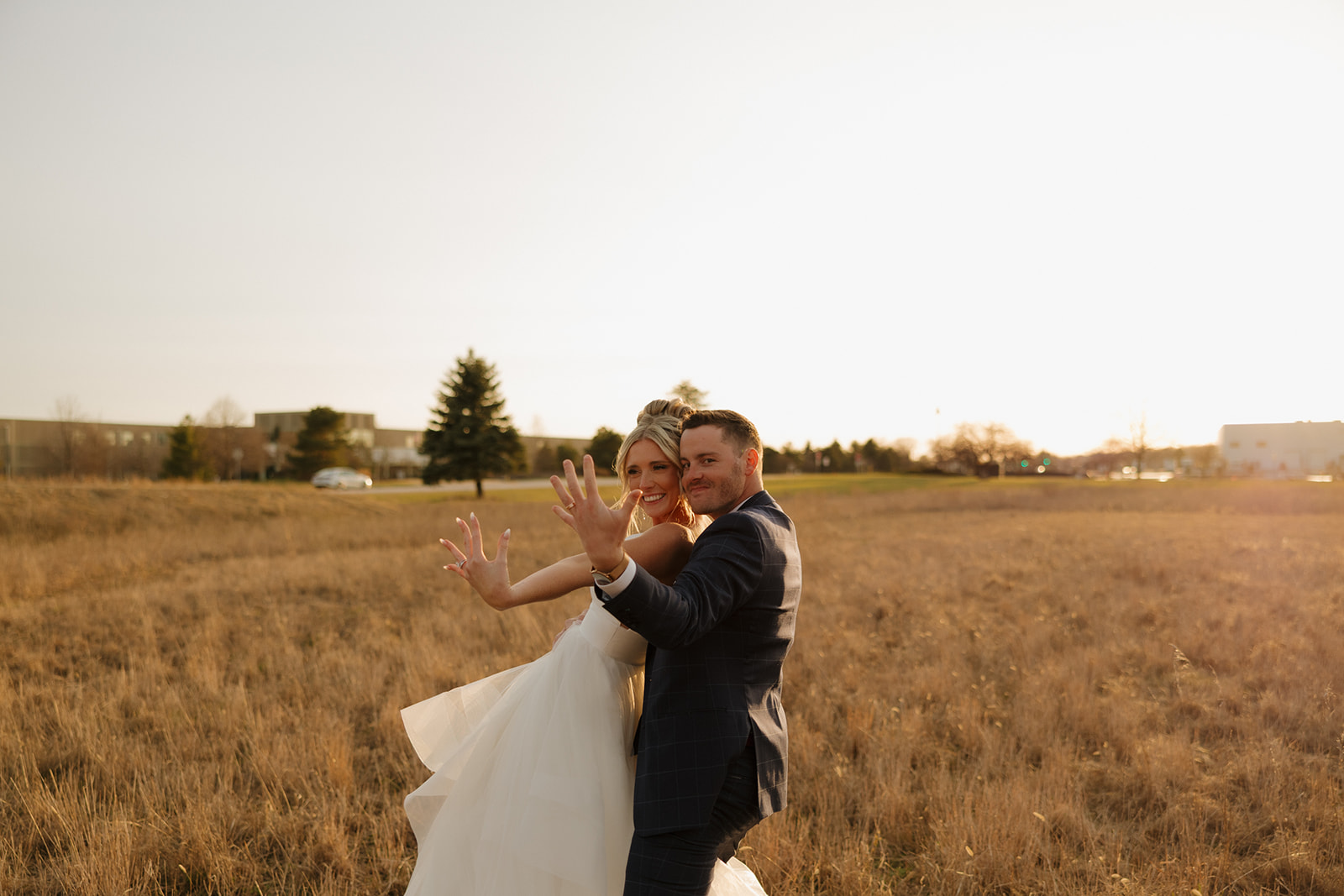 Bride and groom show off their new rings in a playful post-ceremony moment, celebrating their Madison Wisconsin wedding.