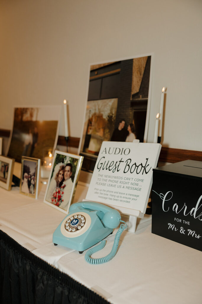 Wedding reception welcome table with an audio guestbook phone, candles, and printed photos at a country club wedding venue.