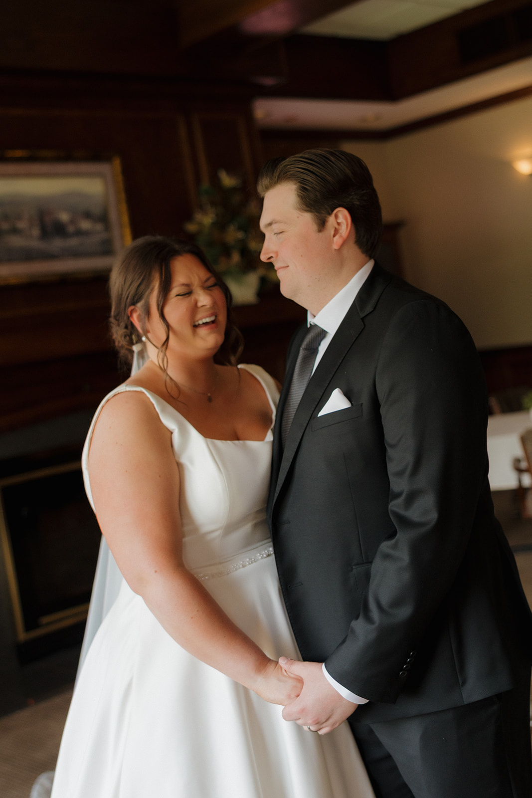 Bride and groom sharing a joyful, candid moment inside the country club wedding venue.