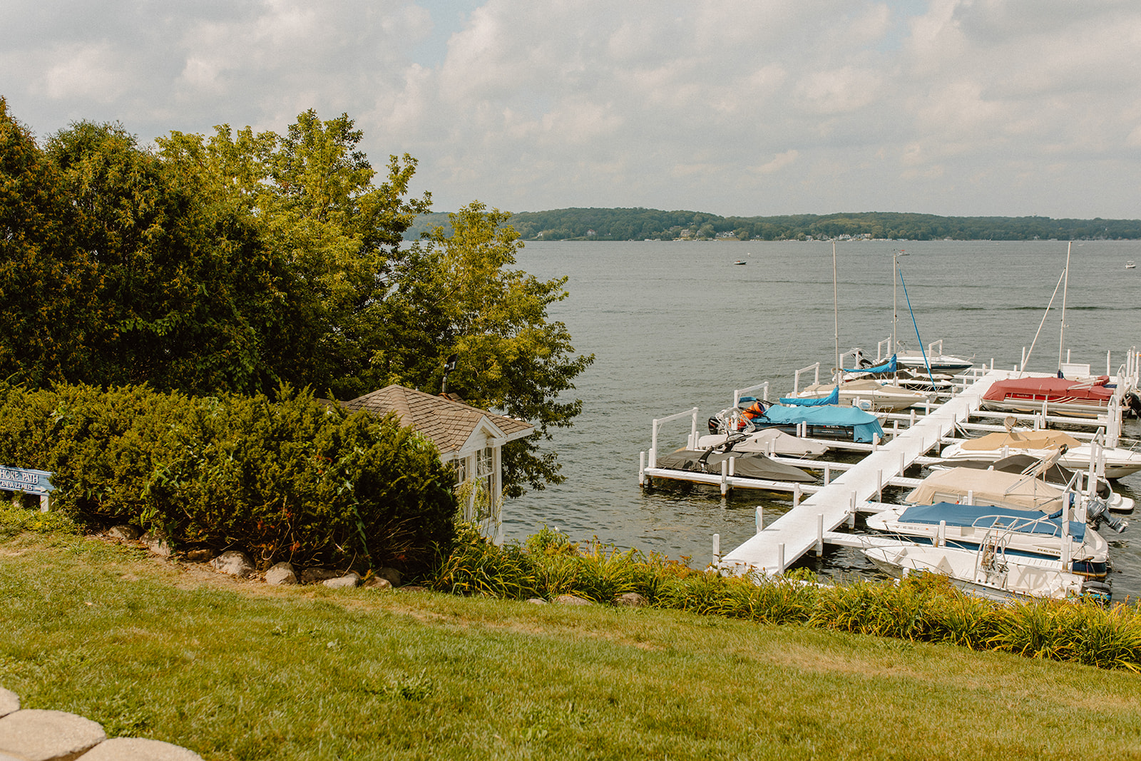 Scenic lakefront view with docks, boats, and lush greenery, highlighting a serene Wisconsin wedding venue by the water.