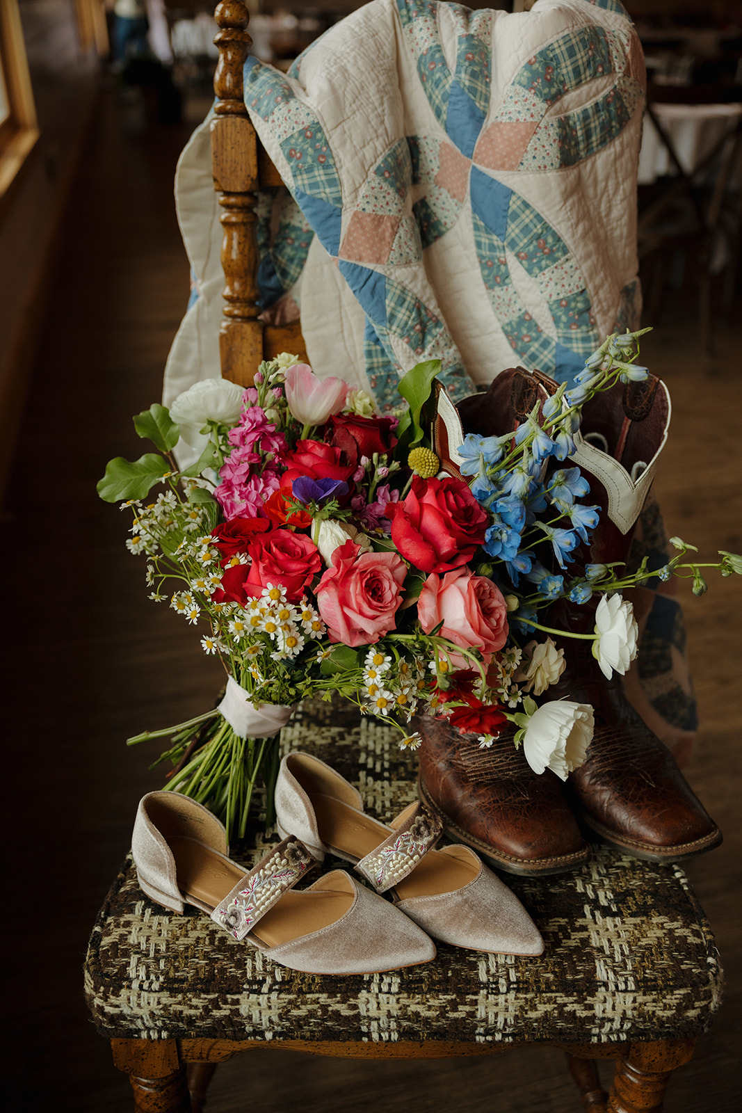 Bridal details styled with cowboy boots, a vintage quilt, velvet shoes, and a bold bouquet—perfect rustic touches for a Wisconsin barn wedding.
