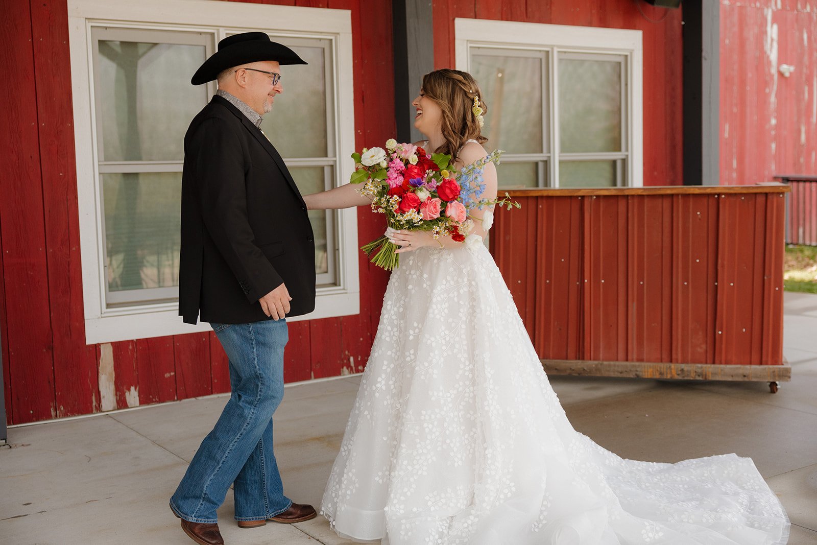 Bride’s emotional first look with her father, both smiling under the barn’s covered patio at Vennebu Hill Wedding Barn & Event Venue.