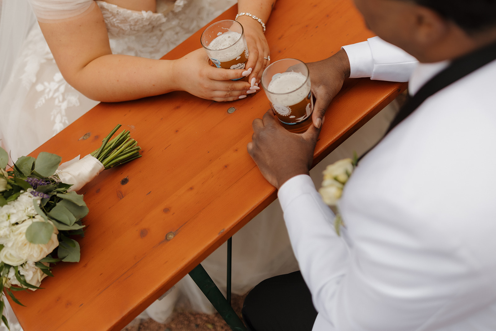 Bride and groom sharing a beer at a local Milwaukee beer garden after their ceremony.