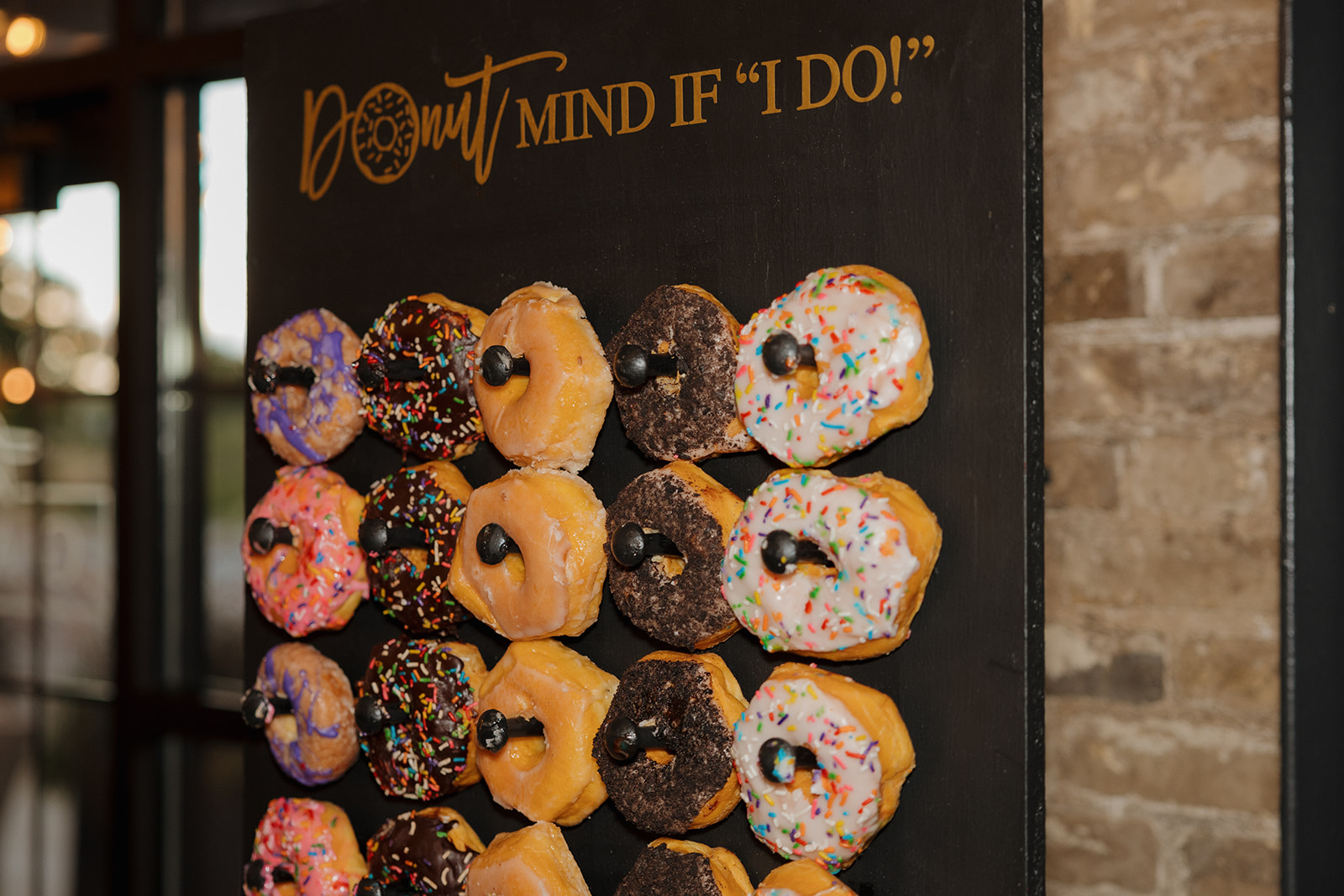 Donut board with donuts hanging on wall during Milwaukee wedding reception at the Gage