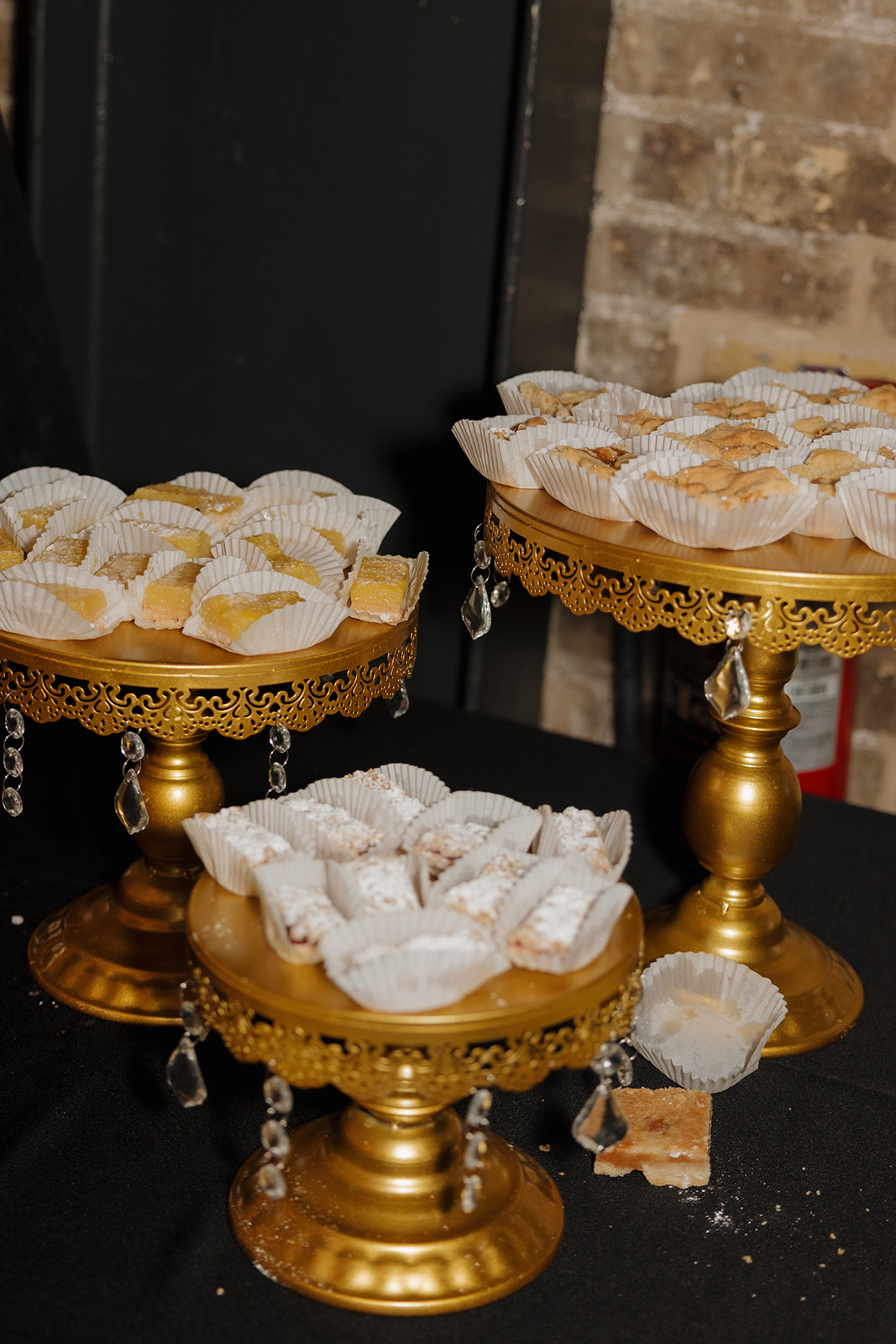 Lemon bars, cannoli, and traditional pastries on ornate gold trays for a stylish Milwaukee wedding dessert display.