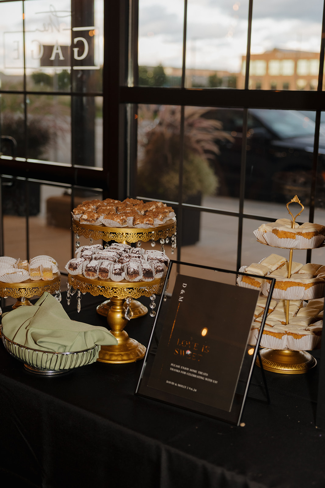 Wedding dessert table with Italian pastries and gold serving stands set up at The Gage venue.