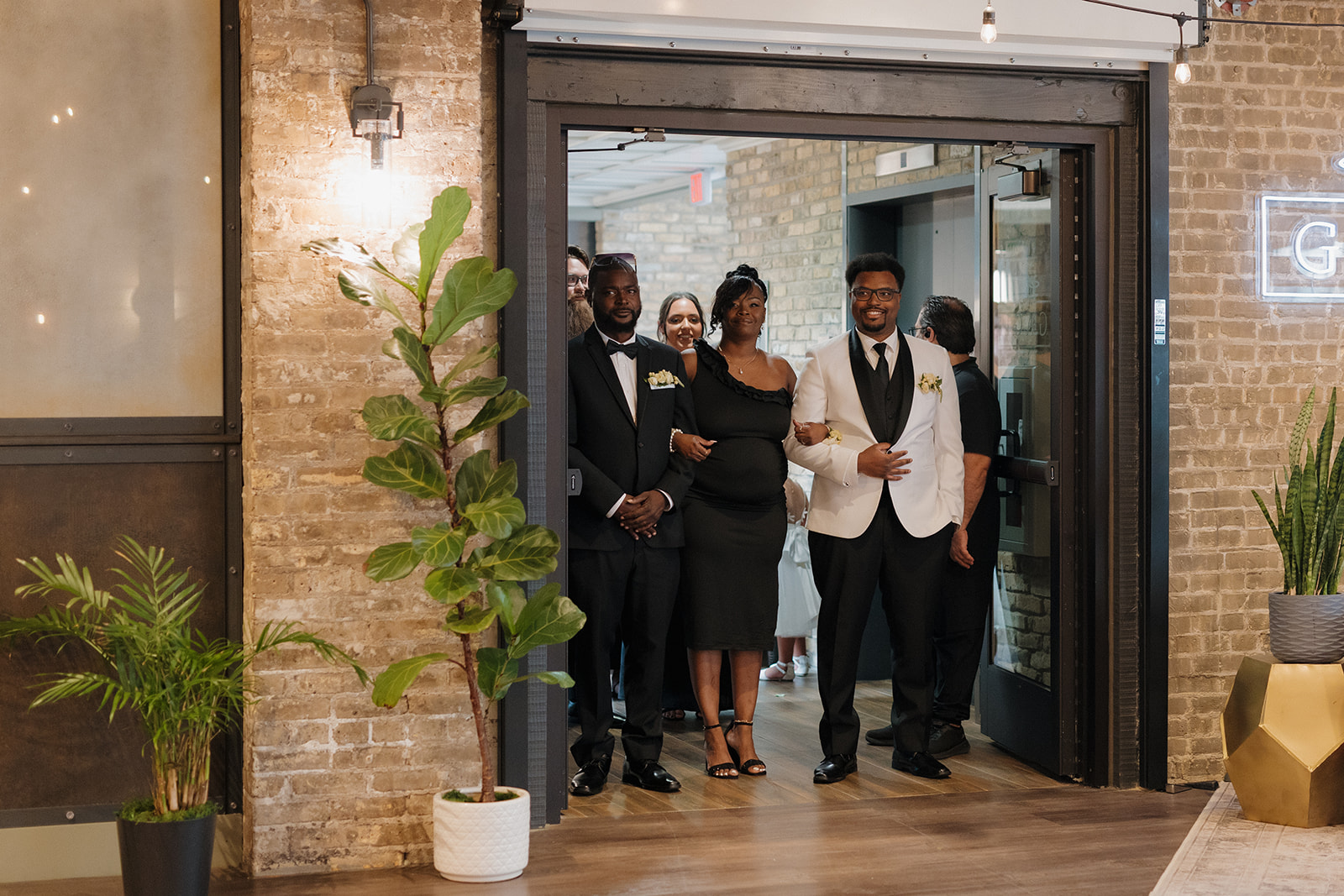 Groom walks into the ceremony space arm-in-arm with his family at The Gage.