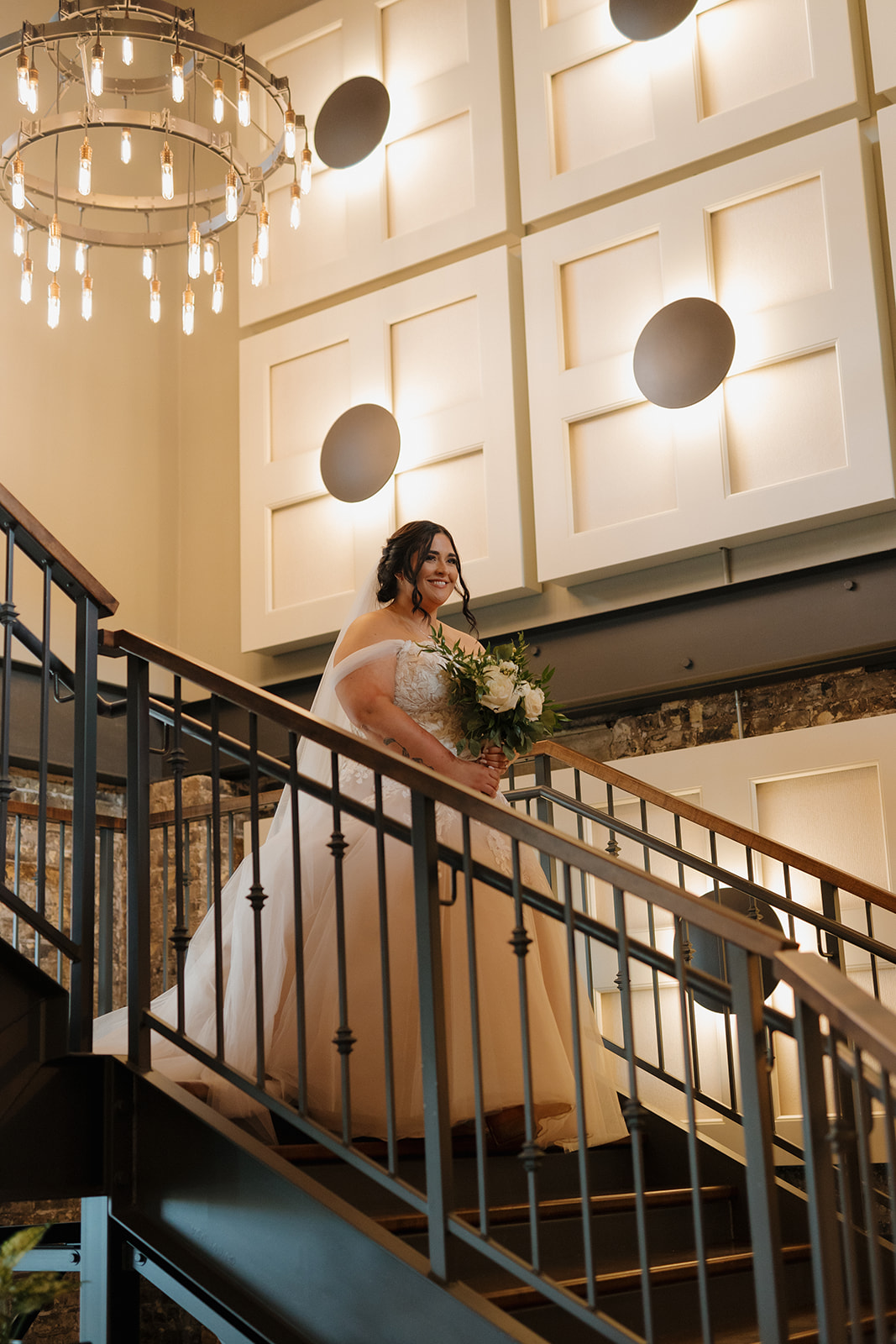 Bride descending the staircase in a ballgown before the ceremony at The Gage wedding venue.