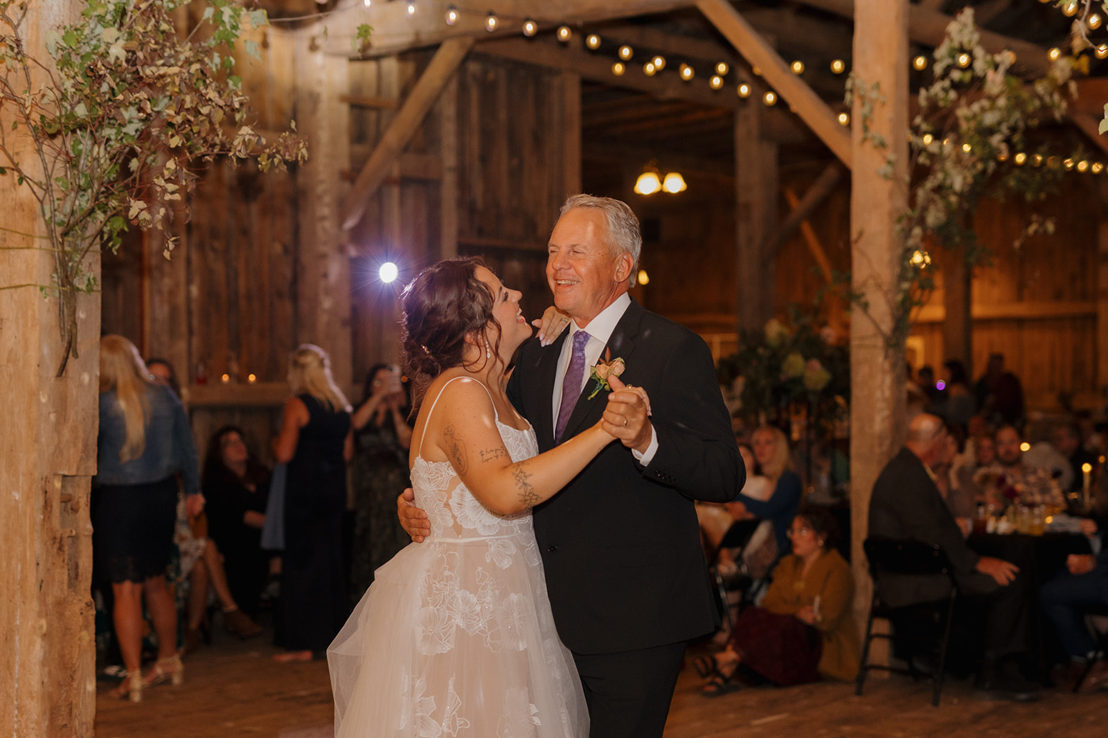 Bride dancing with father during father daughter dance at barn reception