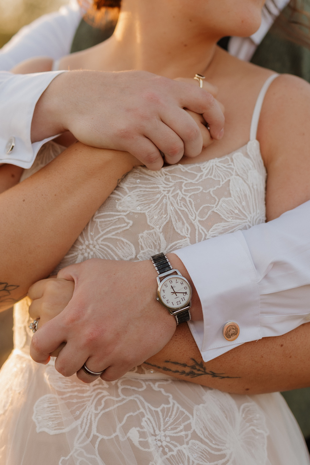 Close up of couple's arms wrapped around one another during golden hour bridals