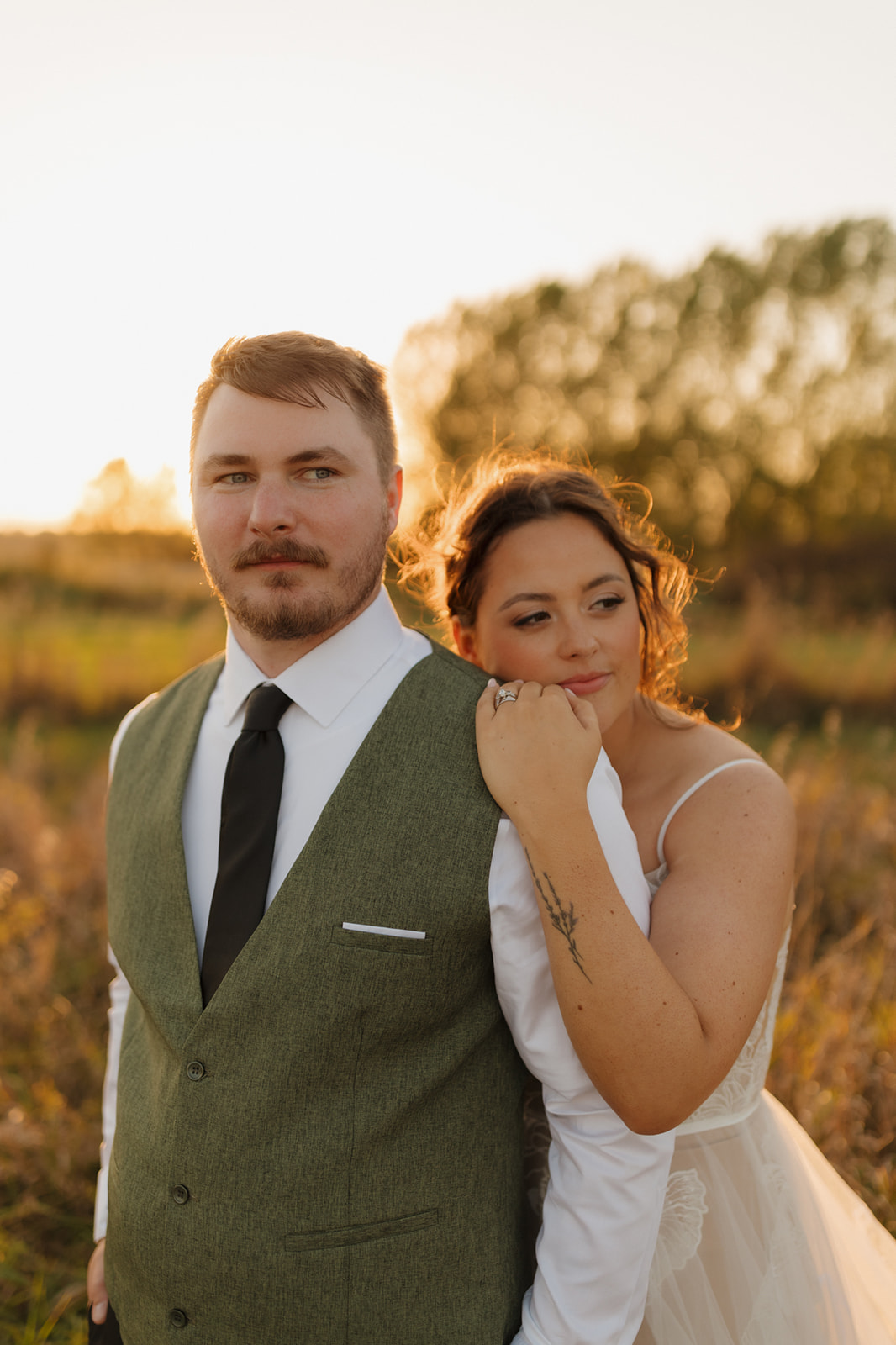 Bride leaning on groom's back with arm around shoulder