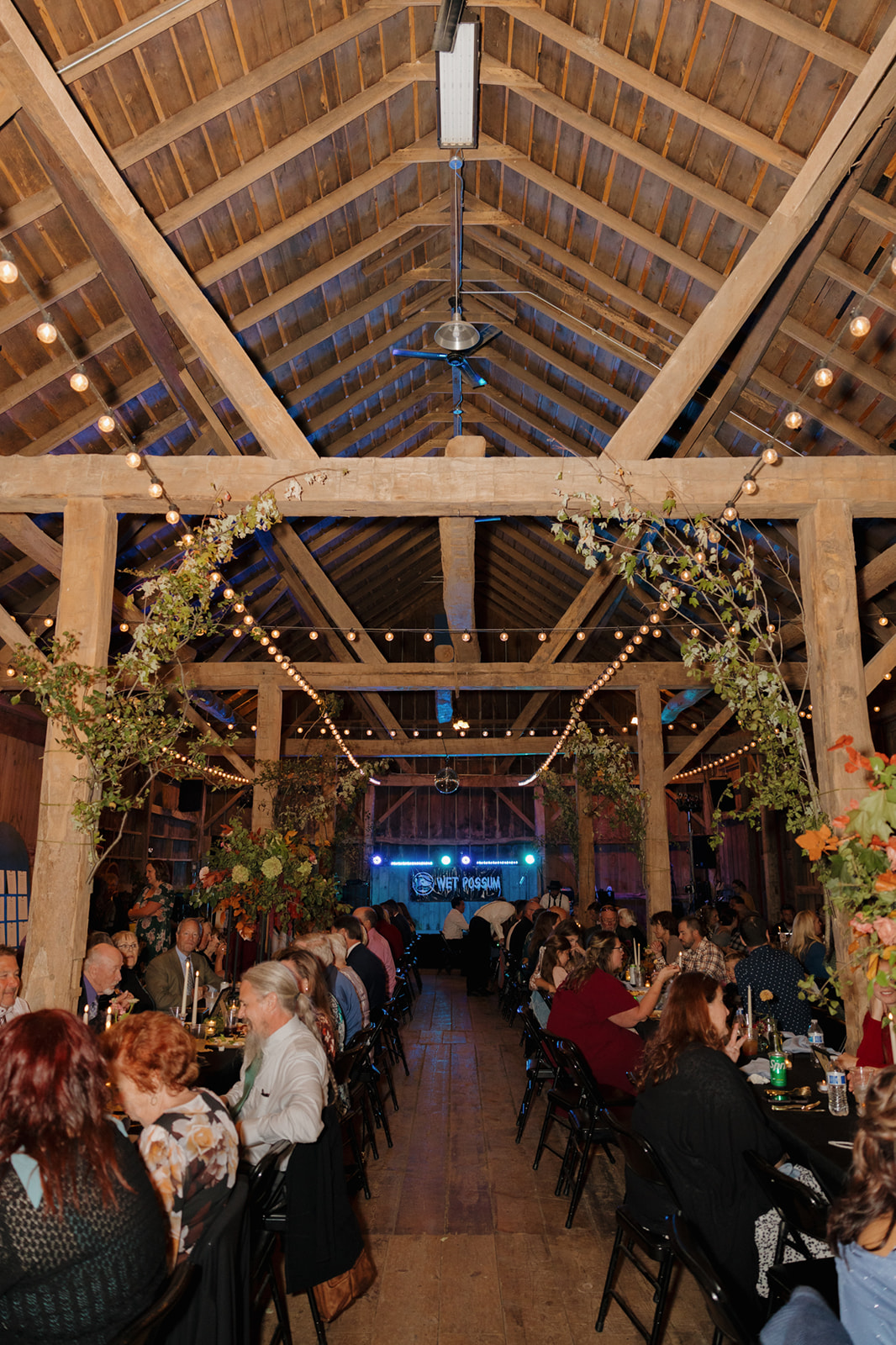 Another view of barn wedding reception with string lights hanging for light and decor