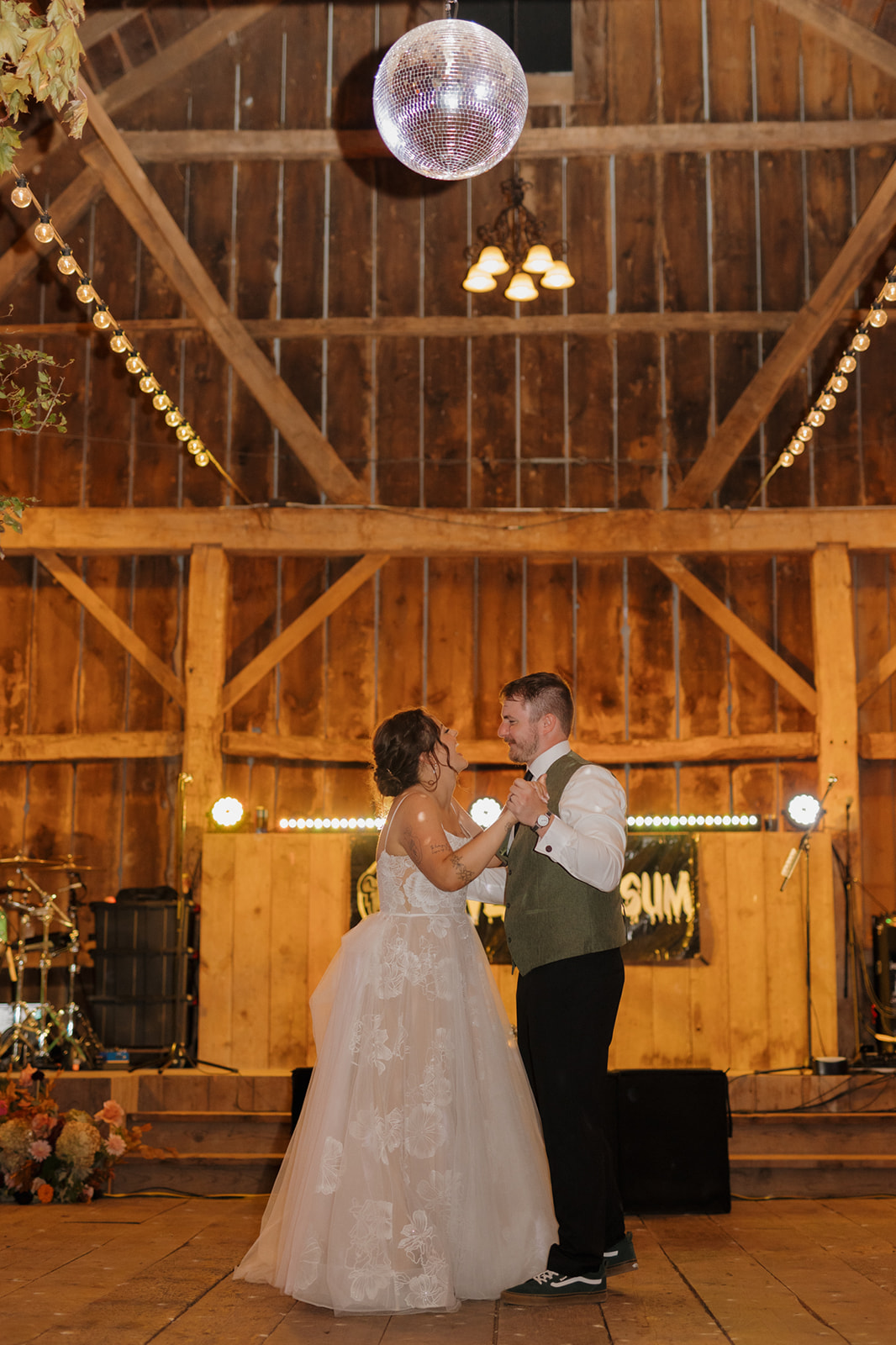 Bride and groom dance during first dance as husband and wife after farm weddings celebration