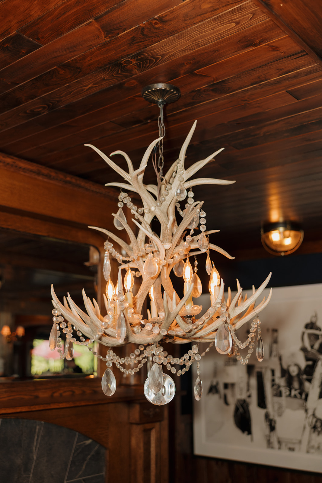 Close-up of an antler chandelier with crystal details at the barn wedding reception venue.