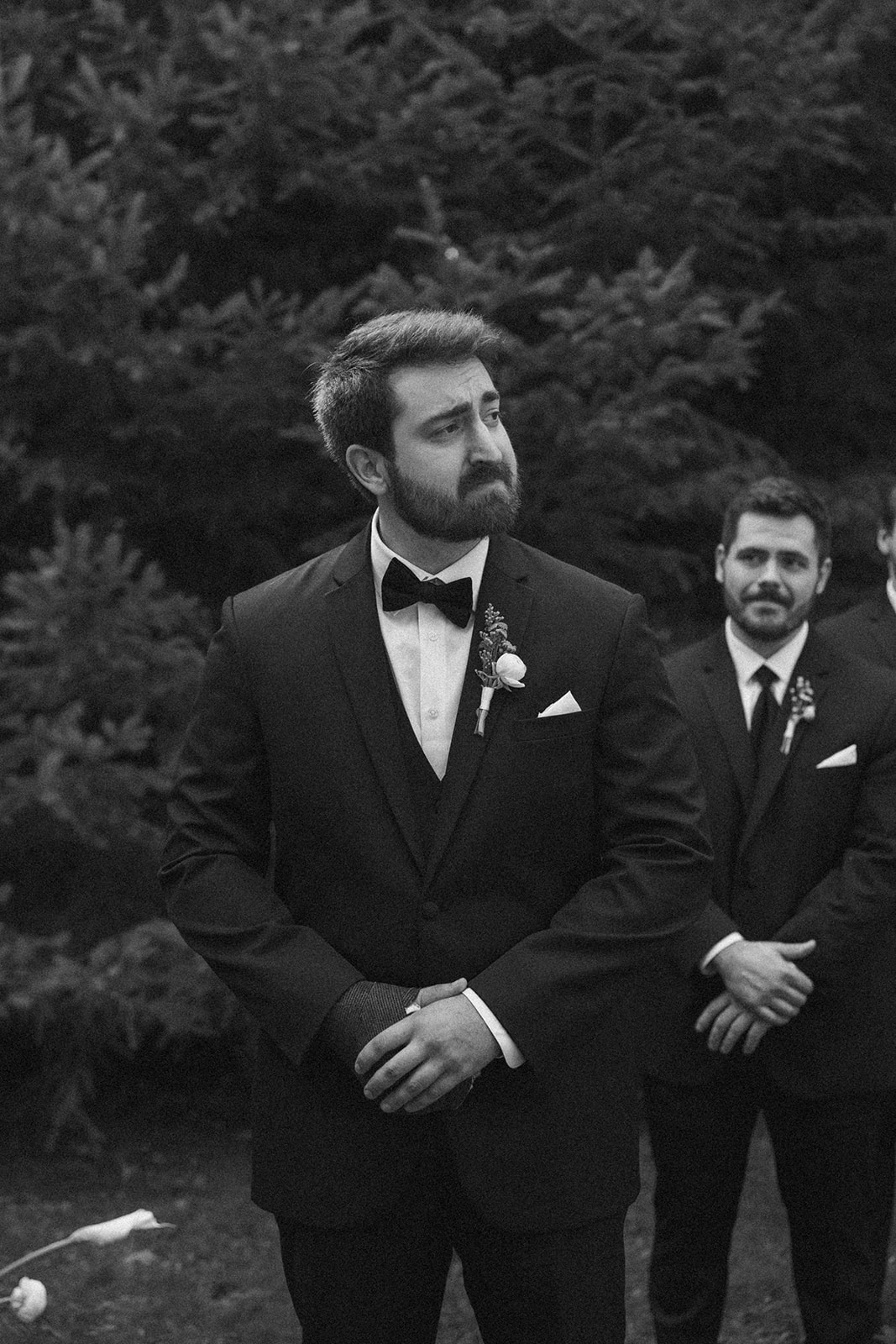 Groom waiting at the altar, looking emotional as the bride approaches.