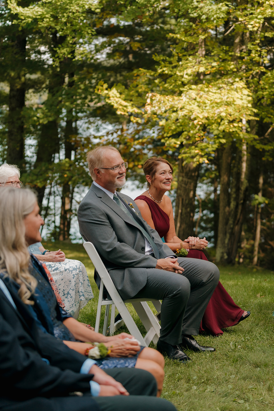 Parents of the couple smiling from the front row of the ceremony.